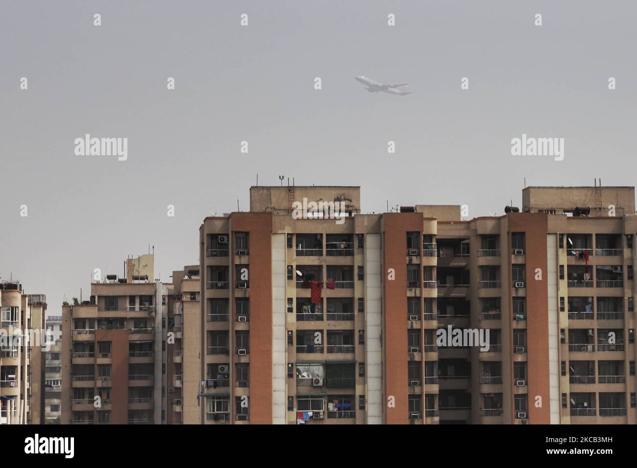 Un aereo passeggeri vola sopra un edificio residenziale a Dwarka, Nuova Delhi, India il 18 marzo 2021. Delhi è rimasta la capitale più inquinata del mondo, ma l'India, nel complesso, ha migliorato i suoi livelli medi annui di PM 2,5 (particolato) più elevati nel 2020 che nel 2019, secondo un rapporto di IQ Air (Foto di Nasir Kachroo/NurPhoto) Foto Stock