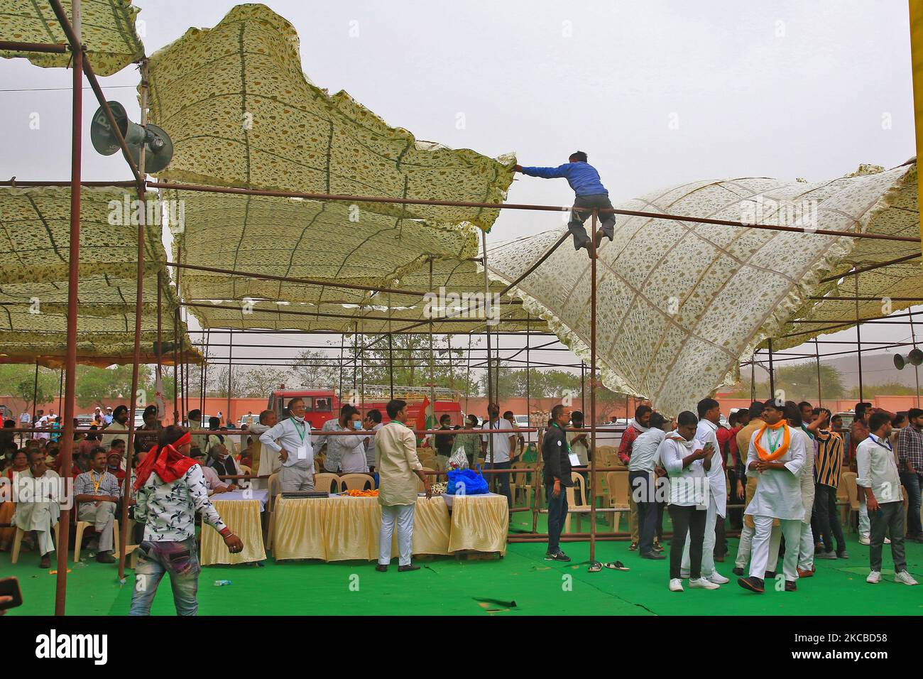 Un lavoratore tenta di controllare le tende nei venti forti durante la riunione pubblica ' Rajasthan Kisan Mahapanchayat' allo Stadio Vidhyadhar Nagar a Jaipur, Rajasthan, India, Martedì, Marzo 23,2021.(Foto di Vishal Bhatnagar/NurPhoto) Foto Stock