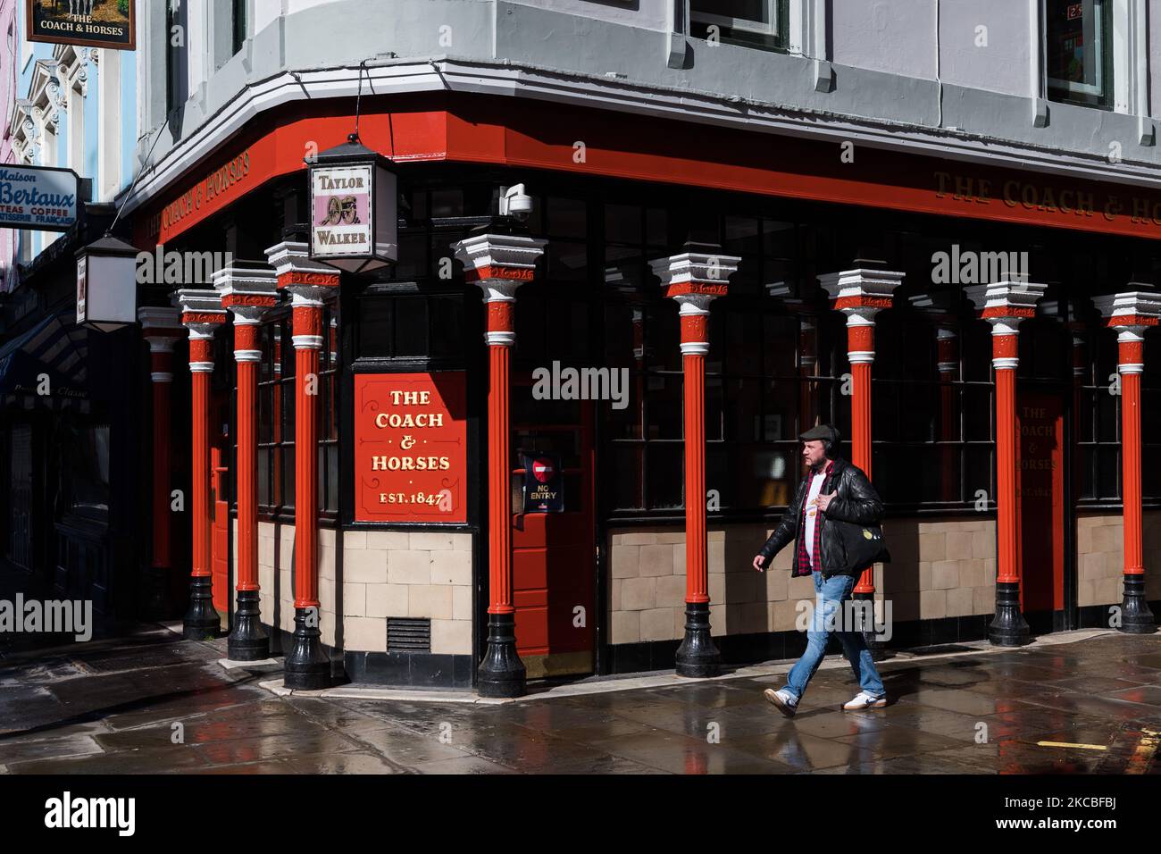 LONDRA, REGNO UNITO - 25 MARZO 2021: Un uomo passa davanti a un pub chiuso a Soho, mentre l'Inghilterra rimane sotto il terzo blocco per ridurre i tassi di infezione di Covid-19, il 25 marzo 2021 a Londra, Inghilterra. Il governo ha definito un piano per sbloccare il paese in quattro fasi man mano che il programma di vaccinazione progredisce, con un'ulteriore riduzione delle restrizioni a partire dal 29 marzo per includere la revoca del soggiorno in ordine di residenza, consentendo a sei persone di incontrarsi all'esterno e l'apertura di strutture sportive all'aperto. (Foto di Wiktor Szymanowicz/NurPhoto) Foto Stock