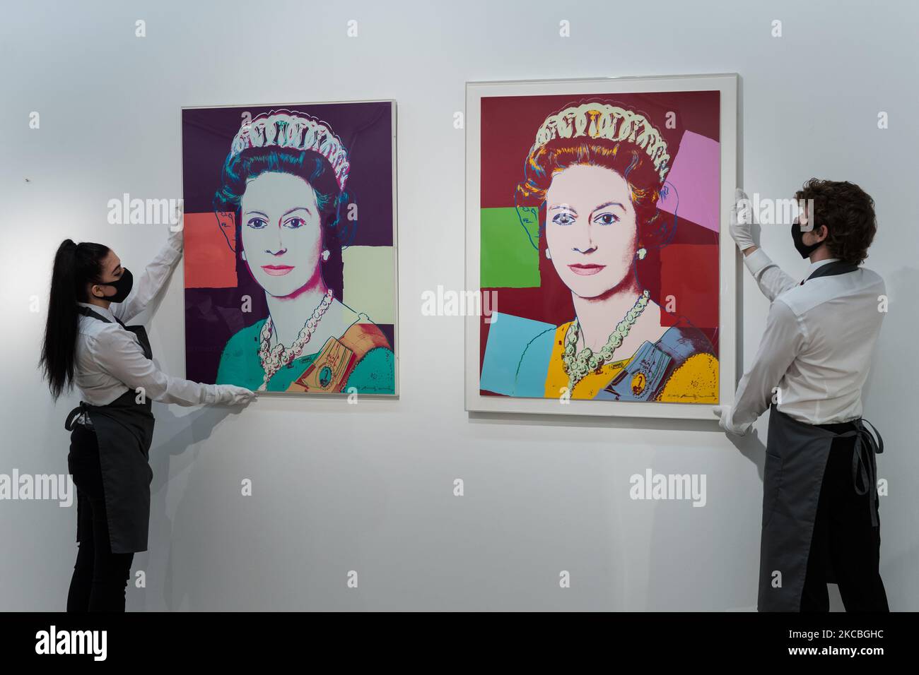 LONDRA, REGNO UNITO - 26 MARZO 2021: I membri dello staff presentano Andy Warhol's (1928-1987) (L-R) Queen Elizabeth II, da: Regning Queens screenprint in Colors, 1985, stima: £70.000-100.000 e Queen Elizabeth II, da: Regning Queens (Royal Edition) screenprint in Colors with Diamond dust, 1985, stima: £100.000-£150.000 durante i preparativi per la vendita online di 'stampe & Multiple' presso la casa d'aste di Christie, il 26 marzo 2021 a Londra, Inghilterra. (Foto di Wiktor Szymanowicz/NurPhoto) Foto Stock