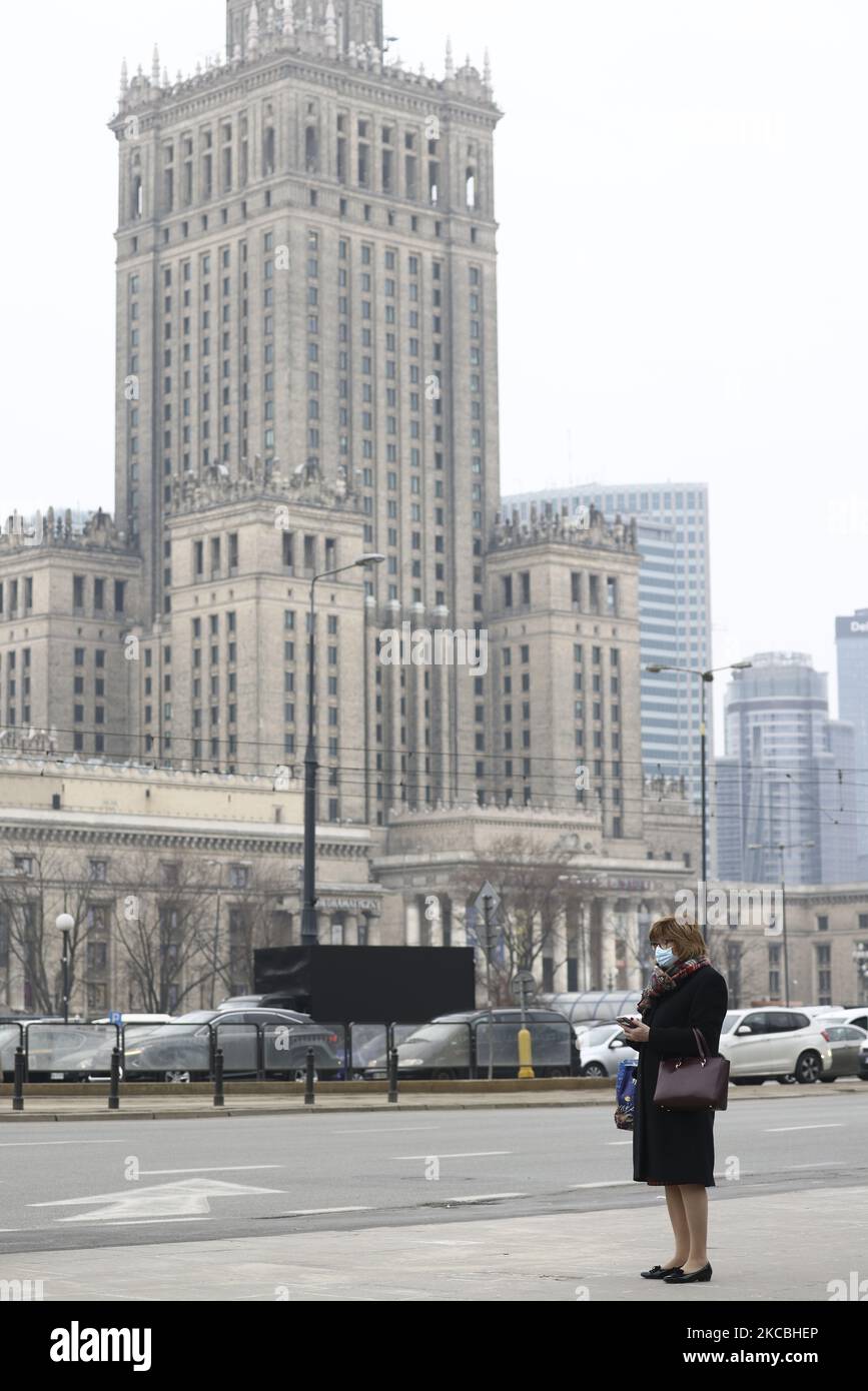 Una donna che indossa una maschera facciale attende un taxi nel centro di Varsavia, Polonia, il 26 marzo 2021. Il governo polacco Giovedi ha annunciato un ulteriore inasprimento delle misure di blocco dopo i nuovi casi di COVID-19 è aumentato al di sopra di 3 mila al giorno. Nuove restrizioni includono la chiusura di scuole materne, centri commerciali e saloni per capelli e unghie. Le restrizioni a partire da sabato dureranno fino al 9 aprile. (Foto di Jaap Arriens/NurPhoto) Foto Stock