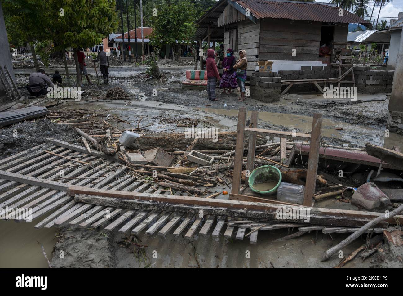 Residenti e volontari hanno ripulito il fango rimasto che ha colpito le case nel villaggio di Beka, nel distretto di Marawola, nella reggenza di Sigi, nella provincia di Sulawesi centrale, in Indonesia il 27 marzo 2021. L'alluvione di fango che si è verificata il 26 marzo 2021 quella notte è stata causata da forti piogge che hanno causato frane in montagna e spazzato via. Insediamenti in quella regione. Non ci sono state vittime nell'incidente, ma almeno 70 case sono state gravemente danneggiate, più di 100 case sono state leggermente danneggiate e inondate da fango, e circa 200 residenti hanno dovuto essere evacuati. (Foto di Basri Marzuki/NurPhoto) Foto Stock