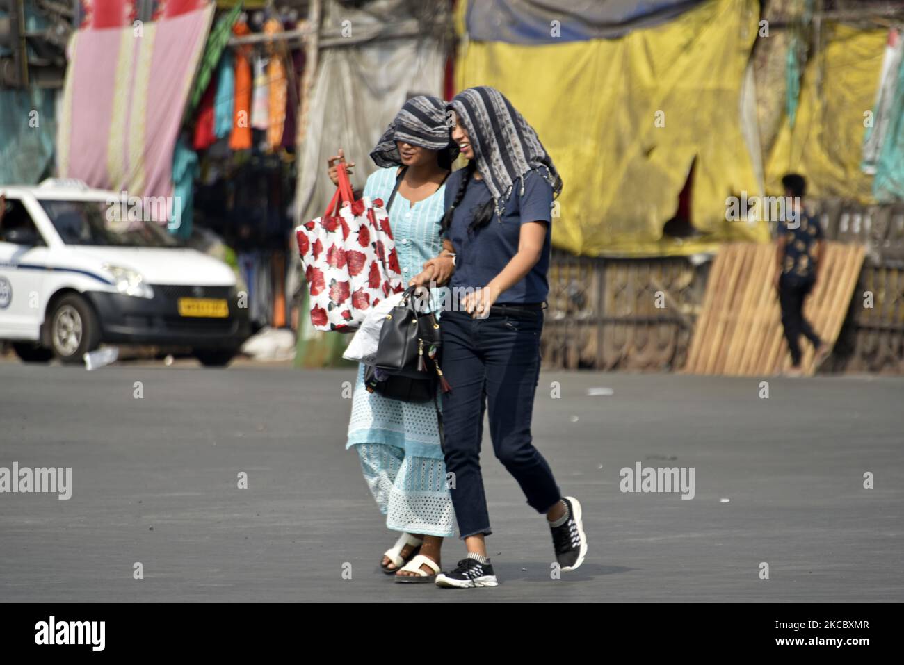 Le donne indiane coprono con una doppiatta (una parte di un abbigliamento indiano) dai raggi del sole durante l'emergenza coronavirus a Kolkata, India, 31 marzo 2021. La città di Kolkata si affaccia sul clima caldo e umido. La temperatura massima e minima è di 38 gradi celsius e 26 gradi celsius secondo un dipartimento meteorologico indiano di Kolkata. (Foto di Indranil Aditya/NurPhoto) Foto Stock