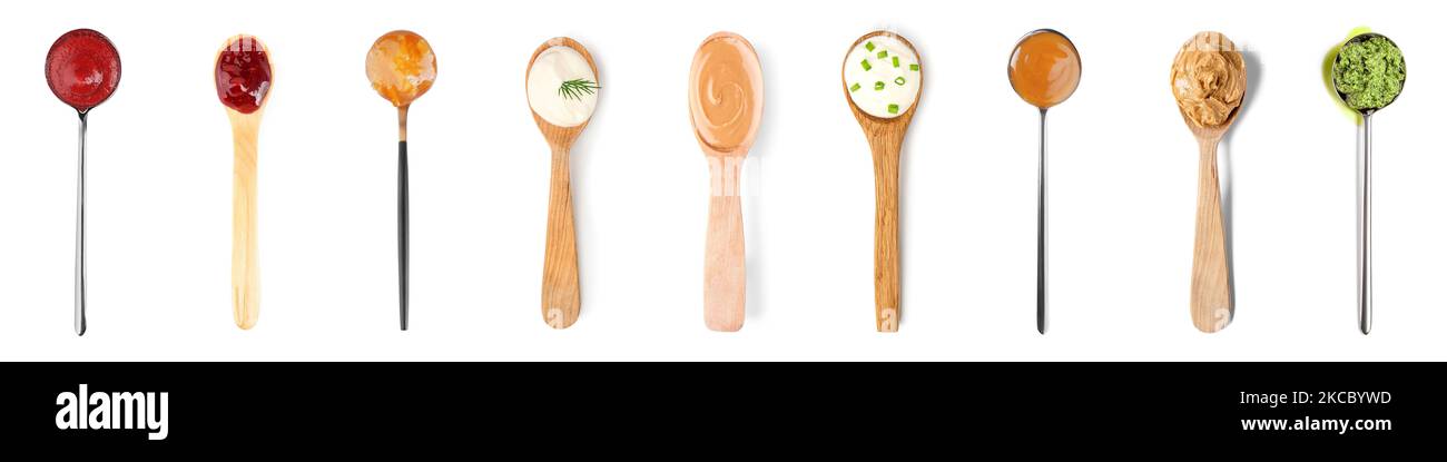 Collage di cucchiai con salse diverse su fondo bianco Foto Stock