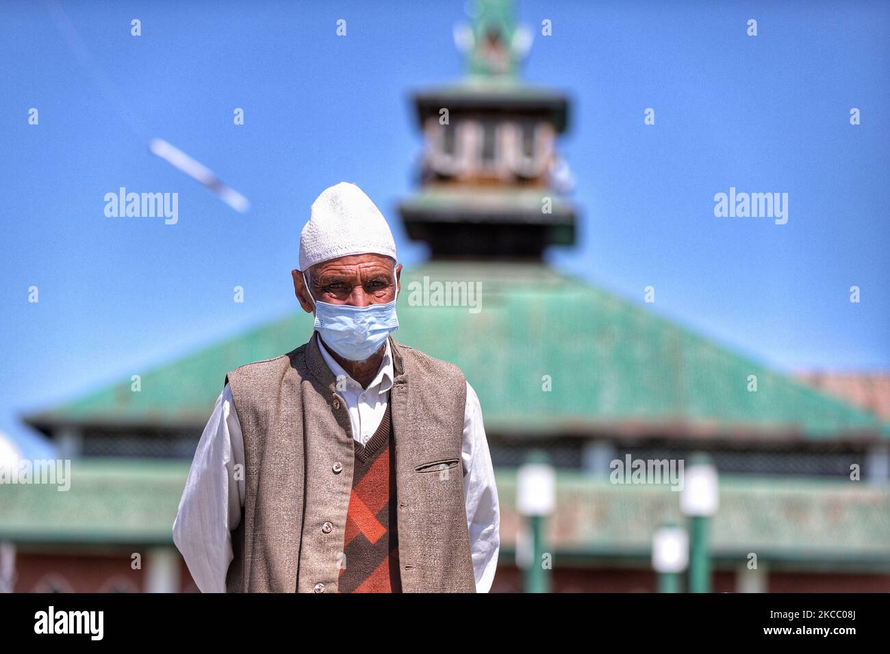 Un uomo musulmano che indossa una maschera cammina vicino a una moschea (Masjid) su un ponte sul fiume Jehlum a Sopore, distretto di Baramulla, Jammu e Kashmir, India il 02 aprile 2021. Una nuova ondata di infezioni da Covid-19 ha scatenato campane di allarme a Jammu e Kashmir, dove le autorità stanno affrontando nuove sfide, tra cui quella scatenata da un afflusso costante di turisti provenienti da diverse parti del paese (Foto di Nasir Kachroo/NurPhoto) Foto Stock