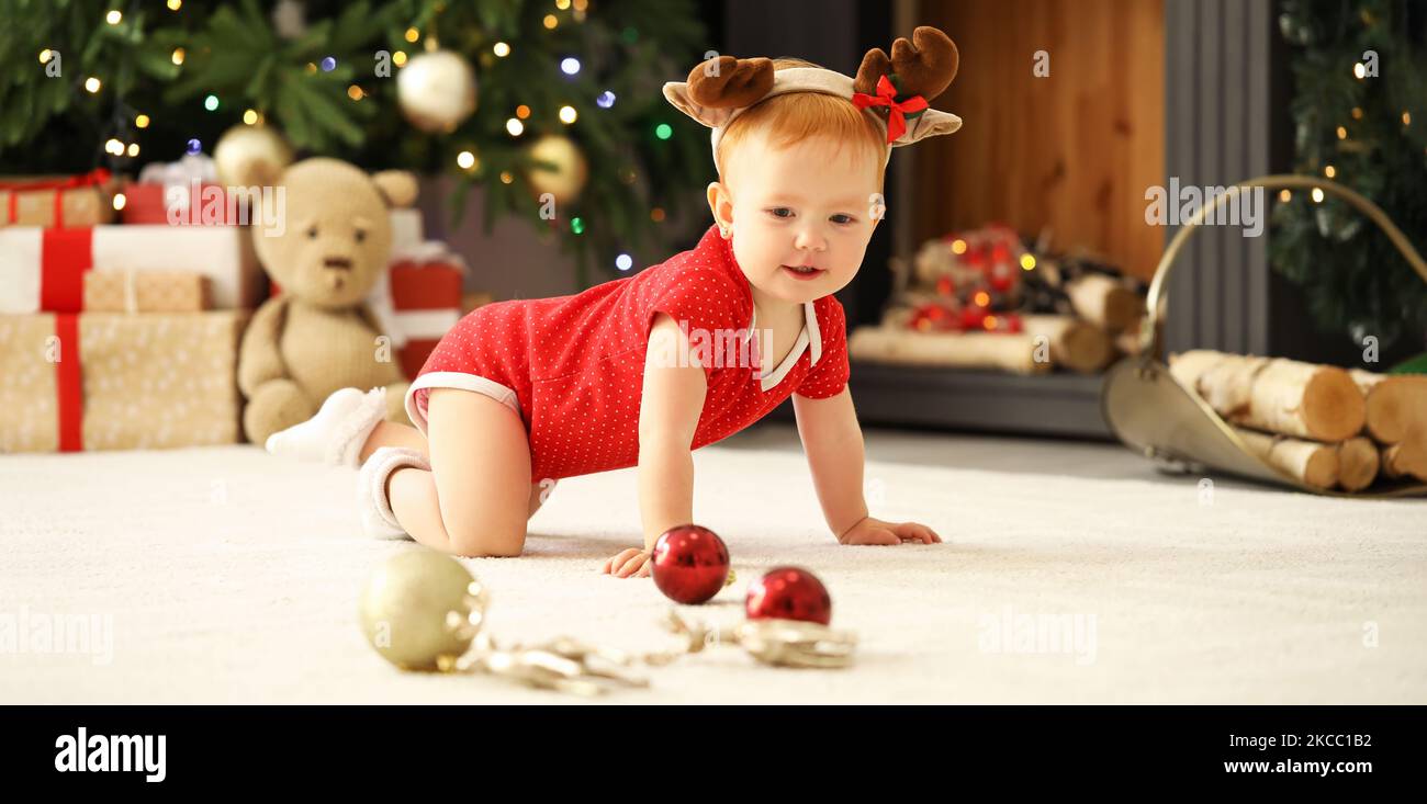 Carino bambino che gioca in camera decorato per Natale Foto Stock