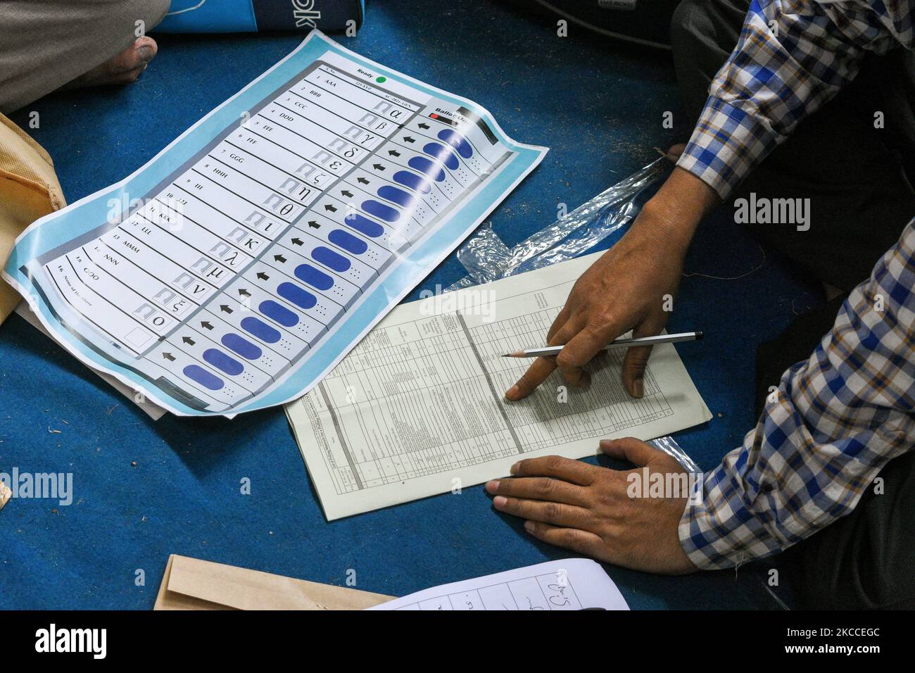 Un addetto al voto che controlla una lista di controllo obbligatoria delle attrezzature e dei documenti che saranno utilizzati durante il voto nella 4th fase delle elezioni dell'Assemblea del Bengala Occidentale a Kolkata , in India , il 9 aprile 2021. (Foto di Debarchan Chatterjee/NurPhoto) Foto Stock