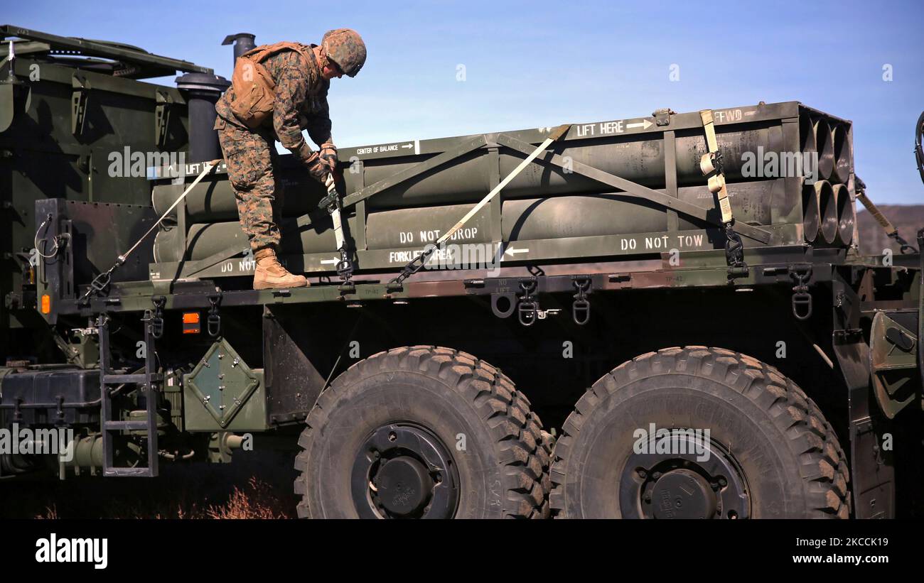 Un Marine degli Stati Uniti controlla le cinghie per fissare un pod di razzo per un sistema di razzo ad alta mobilità artillery. Foto Stock