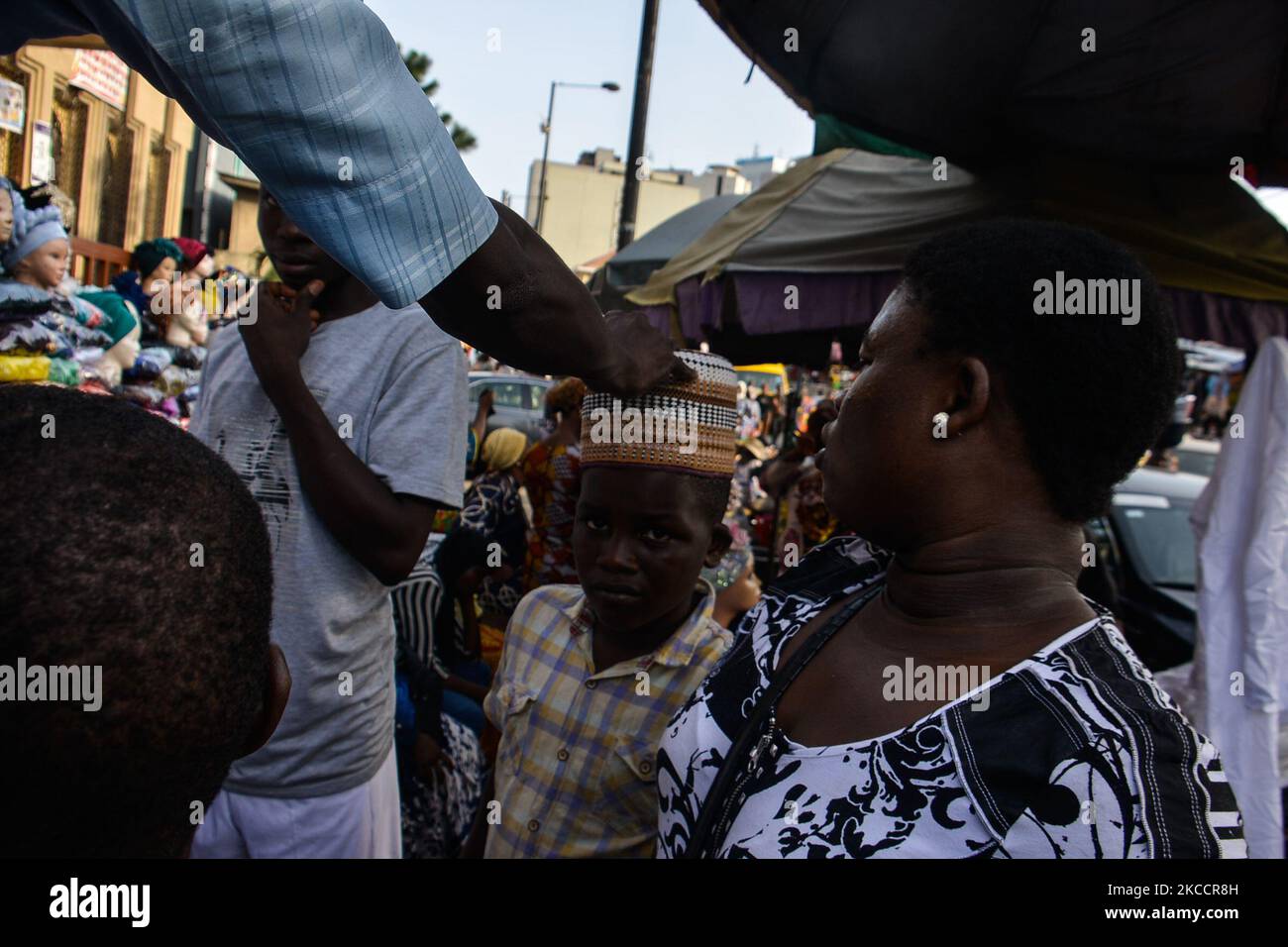 Un negozio di ragazzi musulmani per una tradizionale cuffia nigeriana all'ingresso della Moschea Centrale di Lagos (Isola di Lagos), situata lungo la trafficata strada Nnamdi Azikiwe di Lagos, Nigeria, 14 aprile 2021. I musulmani hanno segnato l'inizio del Ramadan il martedì, Ramadan è segnato da lunghe preghiere, digiuni giù-a-crepuscolo e feste notturne con la famiglia e gli amici anche se l'incontro affollato spalla a spalla nella moschea e la grande riunione per i pasti rimangono vietati a causa della diffusione continua di COVID-19. (Foto di Olukayode Jaiyeola/NurPhoto) Foto Stock