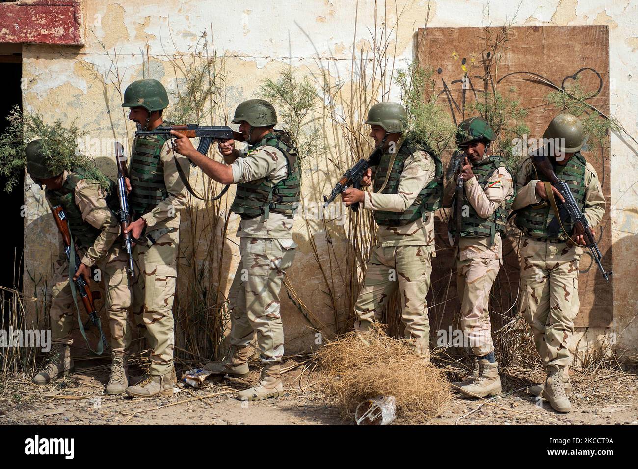 I soldati dell'esercito iracheno si riuniscono in una pila durante l'addestramento di battaglia da vicino. Foto Stock