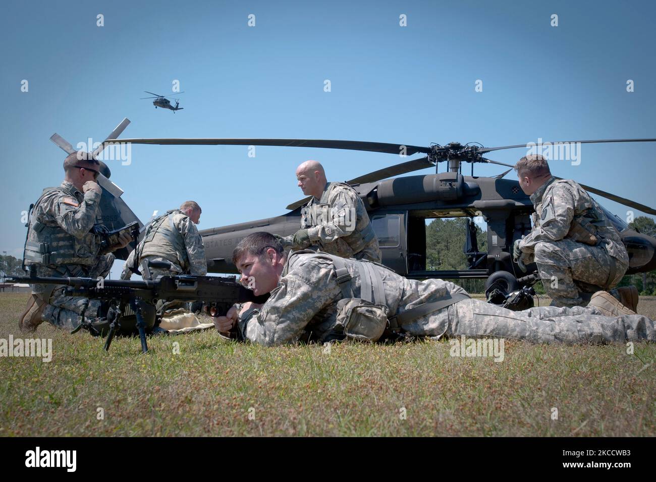 I soldati istituiscono una difesa perimetrale intorno a un elicottero Black Hawk dell'esercito degli Stati Uniti UH-60. Foto Stock