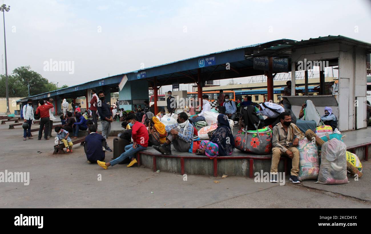 I lavoratori migranti aspettano un autobus mentre partono per i rispettivi villaggi dopo un coprifuoco di sei giorni messo in atto per frenare la diffusione delle infezioni da coronavirus, a Nuova Delhi il 20 aprile 2021. L’India ha registrato ufficialmente più di 2 milioni (20 lakh) di casi attivi di Covid-19, attualmente il secondo numero al mondo dopo gli Stati Uniti. (Foto di Mayank Makhija/NurPhoto) Foto Stock