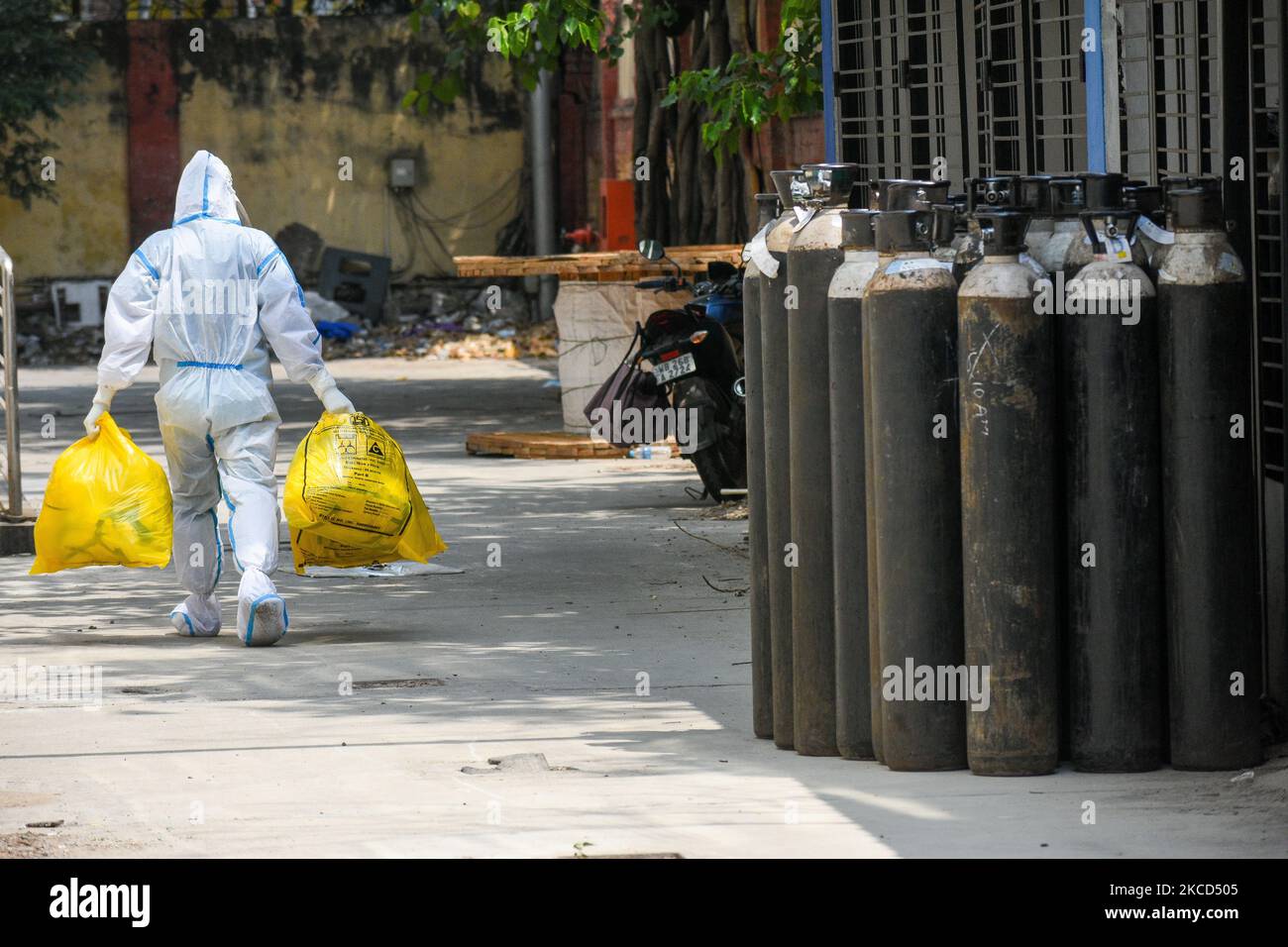 Un operatore sanitario che indossa il kit dpi passa in contenitori vuoti di ossigeno in un ospedale di Kolkata, India, il 21 aprile 2021. L'India ha registrato più di 2,9 casi Lakh e 2000 morti ieri, i paesi più alti picchi ancora secondo i media indiani rapporto. (Foto di Debarchan Chatterjee/NurPhoto) Foto Stock