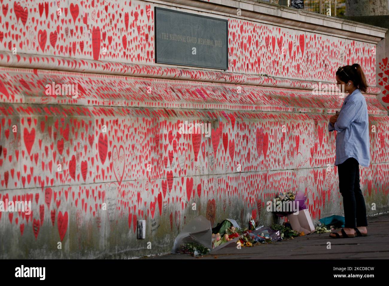 Una donna guarda il National Covid Memorial Wall of Hearts, ogni cuore che rappresenta una morte individuale di coronavirus, a Londra, in Inghilterra, il 22 aprile 2021. (Foto di David Cliff/NurPhoto) Foto Stock