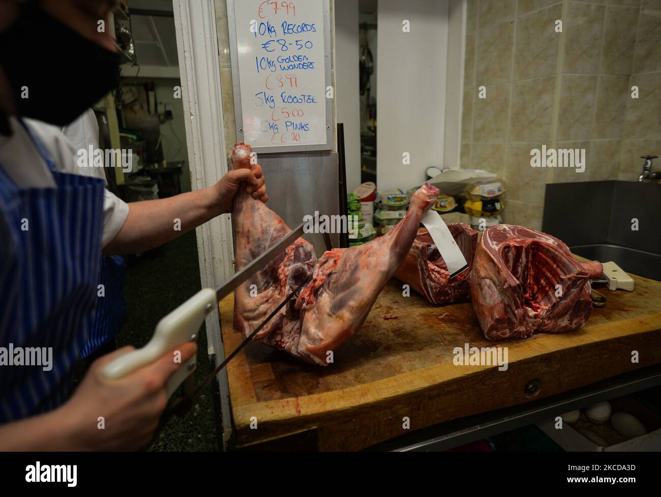 Laurance, proprietario dei macellai della famiglia Morana, taglia in parti un tradizionale agnello Connemara. Due anni fa, poco prima dell'inizio della pandemia di Covid-19, dopo vent'anni di apprendistato, assunse la proprietà dei macellai per continuare a fornire alla comunità prodotti tradizionali di provenienza locale e mantenere servizi autentici di alta qualità. Venerdì 23 aprile 2021, a Clifden, Connemara, County Galway, Irlanda.. (Foto di Artur Widak/NurPhoto) Foto Stock