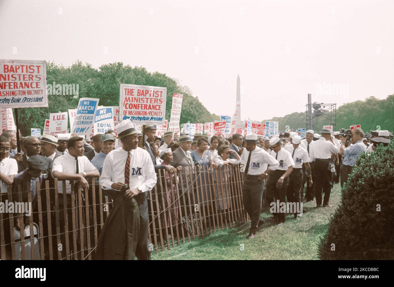 Esegue il marshalling in piedi dal recinto vicino folla recanti segni durante il mese di marzo su Washington, 1963 Foto Stock