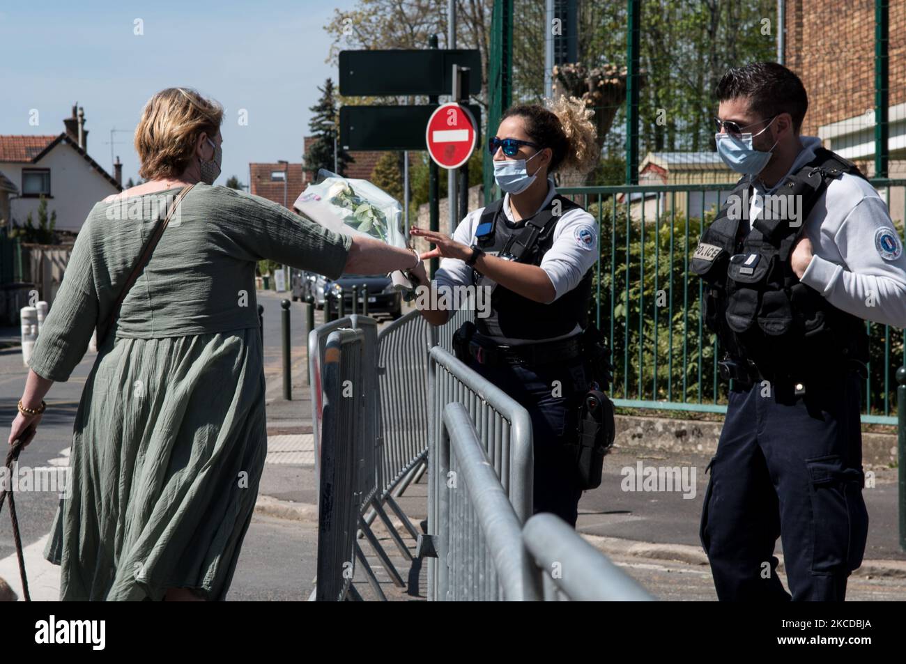 Un poliziotto riceve un mazzo di fiori da una donna che rende omaggio all'ufficiale di polizia ucciso in un attacco alla stazione di polizia, a Rambouillet, Parigi, il 24 aprile 2021. (Foto di Andrea Savorani Neri/NurPhoto) Foto Stock