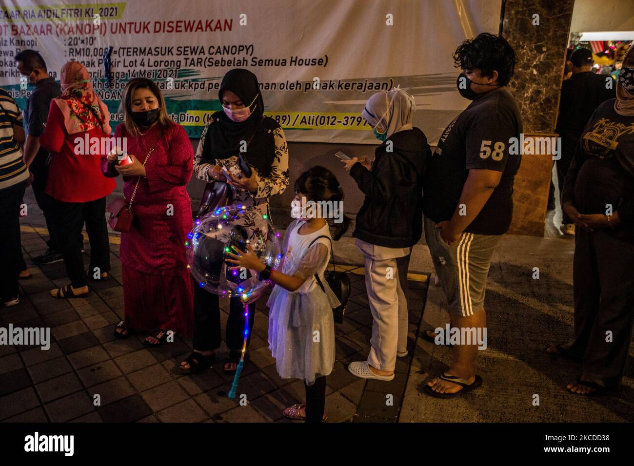 La gente fa la coda mentre aspettano di entrare in un bazar del Ramadan durante il mese santo del Ramadan a Kuala Lumpur, il 25 aprile 2021. Durante il mese santo del Ramadan, un bazar quotidiano offre varie selezioni di abbigliamento, cibo, tappeti di preghiera e altri articoli religiosi ai musulmani che tradizionalmente acquistano nuovi abiti per accogliere la fine del mese, le celebrazioni Eid al-Fitr in Malesia. (Foto di Mohd Firdaus/NurPhoto) Foto Stock