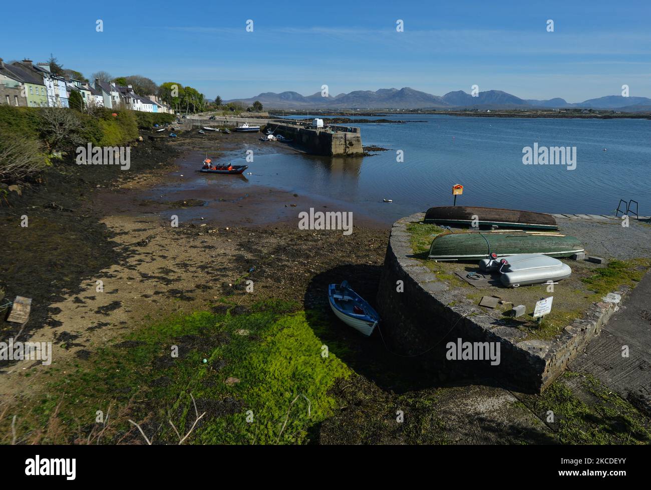 Una vista generale del porto di Roundstone durante la bassa marea, durante il blocco COVID-19. Da oggi, l'Irlanda sta allentando alcune restrizioni, tra cui la riapertura di impianti sportivi all'aperto, campi sportivi, campi da golf e da tennis. Le attività sportive senza contatto come il golf e il tennis possono riprendere. Riapriranno anche alcune attrazioni turistiche, tra cui giardini zoologici, fattorie animali aperte e siti storici, ma non parchi divertimenti. Tutti i servizi di ospitalità in queste aree saranno disponibili solo per i servizi da take-away e verranno applicati limiti di capacità. Il governo sta lavorando ai piani per riaprire gli hotel da presto Foto Stock