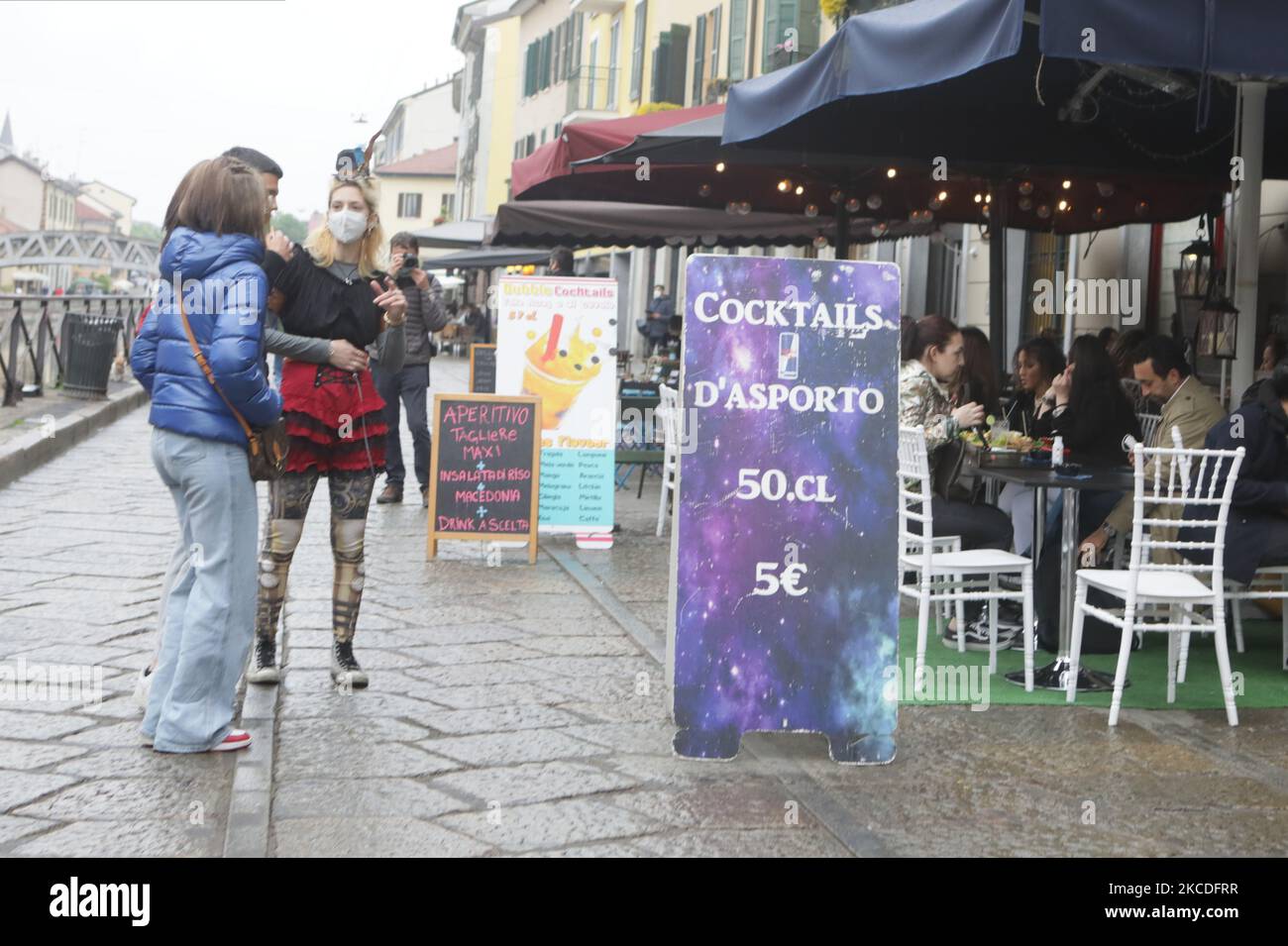 La gente ha un drink sulla terrazza del bar dei Navigli nel centro di Milano, Italia il 26 aprile 2021, mentre i bar, i ristoranti, i cinema e le sale da concerto riaprono parzialmente in Italia per dare impulso alle imprese colpite dal coronavirus, mentre il parlamento discute il piano di ripresa finanziato dall'UE del governo, che ammonta a 220 miliardi di euro (266 miliardi di dollari). – Dopo mesi di restrizioni stop-start imposte per gestire la seconda e la terza ondata di Covid-19, l’Italia spera che quest’ultimo allentamento segnerà l’inizio di una normale estate. (Foto di Mairo Cinquetti/NurPhoto) Foto Stock