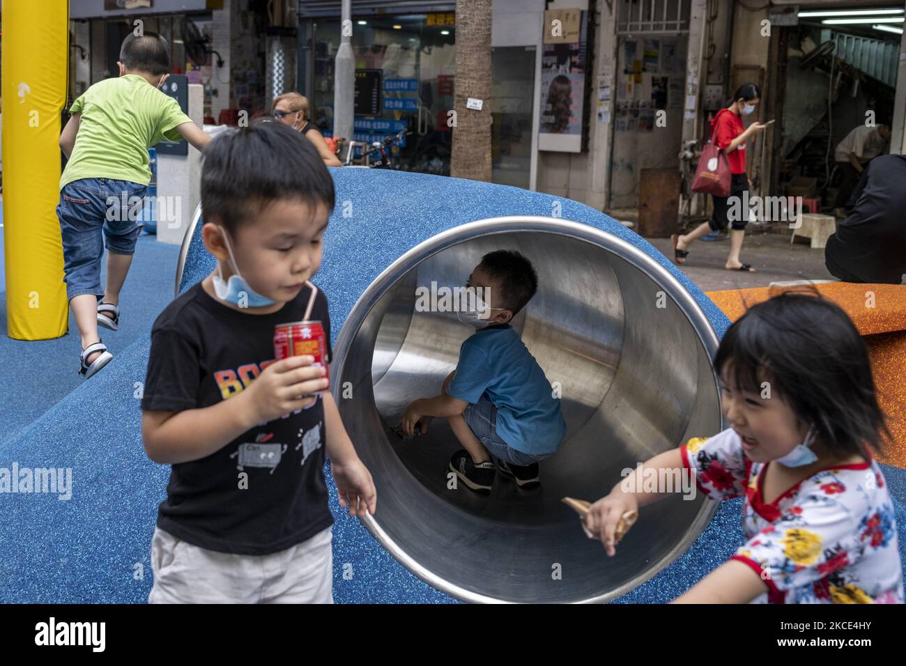 I bambini che indossano maschere facciali giocano in un parco di Hong Kong, Cina, il 6 maggio 2021. (Foto di Vernon Yuen/NurPhoto) Foto Stock