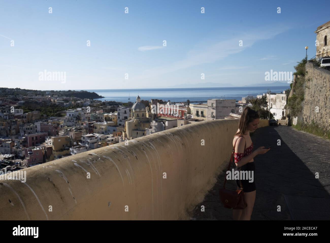 Un turista controlla il suo telefono durante una visita all'isola di Procida. Procida, una piccola isola vicino a Napoli, è la prima isola libera di Covid in Italia, poiché tutta la popolazione ha ricevuto la vaccinazione. Inoltre, l'isola era stata nominata capitale della cultura italiana 2022, Procida, 10th maggio 2021. (Foto di Francesco Boscarol/NurPhoto) Foto Stock