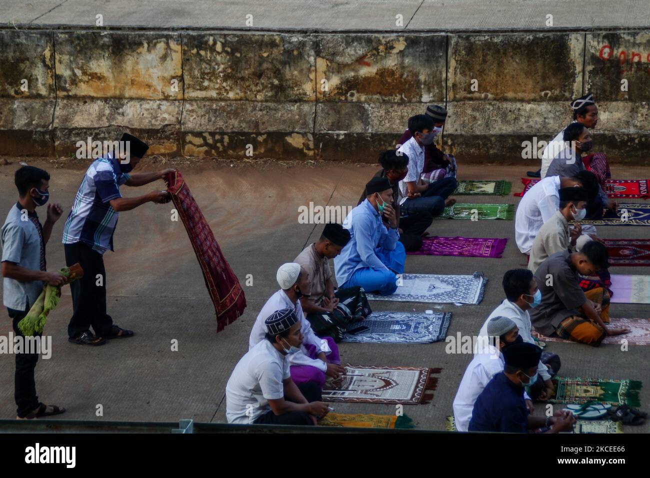 I musulmani indonesiani si preparano mentre eseguono la preghiera di Eid al-Fitr sulla strada a pedaggio Cisumdawu a Pamulihan, nella reggenza di Sumedang, in Indonesia il 13 2021 maggio. I musulmani di tutto il mondo celebrano Eid al-Fitr con le loro famiglie per celebrare la fine del Ramadan, il mese santo del digiuno. Le autorità indonesiane hanno proibito il ritorno a casa per le festività per segnare la fine del Ramadan per impedire la diffusione del COVID-19. (Foto di Algi Libri Sugita/NurPhoto) Foto Stock