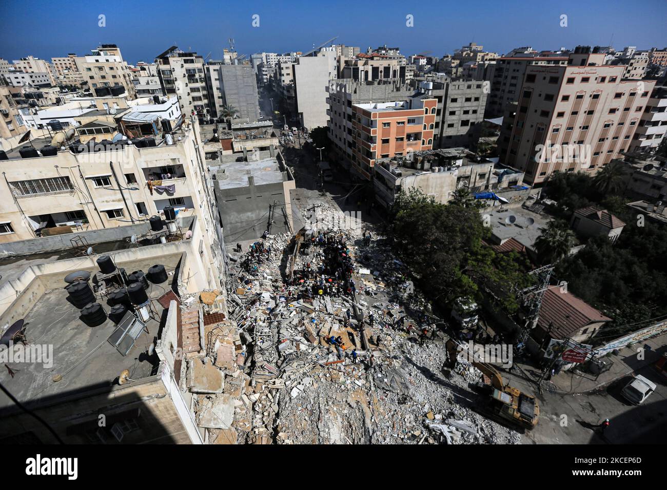 Un palestinese evacua la bambina figlia dalle macerie di una casa distrutta dopo uno sciopero aereo israeliano a Gaza City, il 16 maggio 2021. Un totale di 174 persone sono state uccise nelle incursioni israeliane a Gaza, tra cui 47 bambini e 29 donne (Foto di Momen Faiz/NurPhoto) Foto Stock