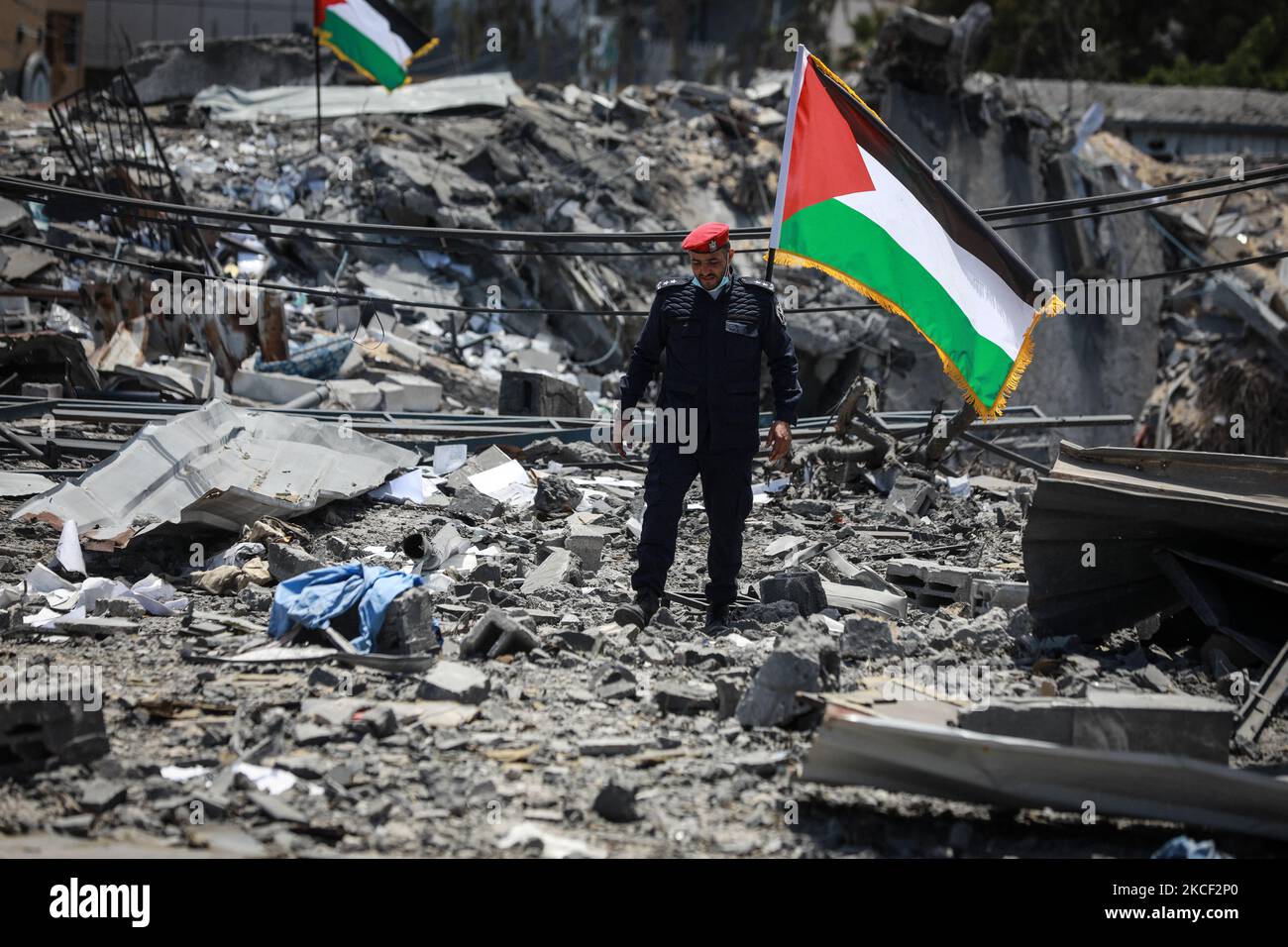 Un poliziotto palestinese cammina sulle macerie di Arafat City, il quartier generale della polizia di Gaza a Gaza City il 22 maggio 2021, a seguito di un cessate il fuoco tra Israele e militanti palestinesi nell'enclave israeliana bloccata. - Come sostiene il cessate il fuoco, gli aiuti umanitari hanno cominciato ad entrare nell'enclave devastata da 11 giorni di spargimento di sangue. Mentre migliaia di palestinesi sfollati sono tornati alle loro case, e gli israeliani hanno iniziato a riprendere la vita normale un giorno prima, l'attenzione internazionale si è rivolta alla ricostruzione della striscia di Gaza, devastata dalla bomba. (Foto di Majdi Fathi/NurPhoto) Foto Stock