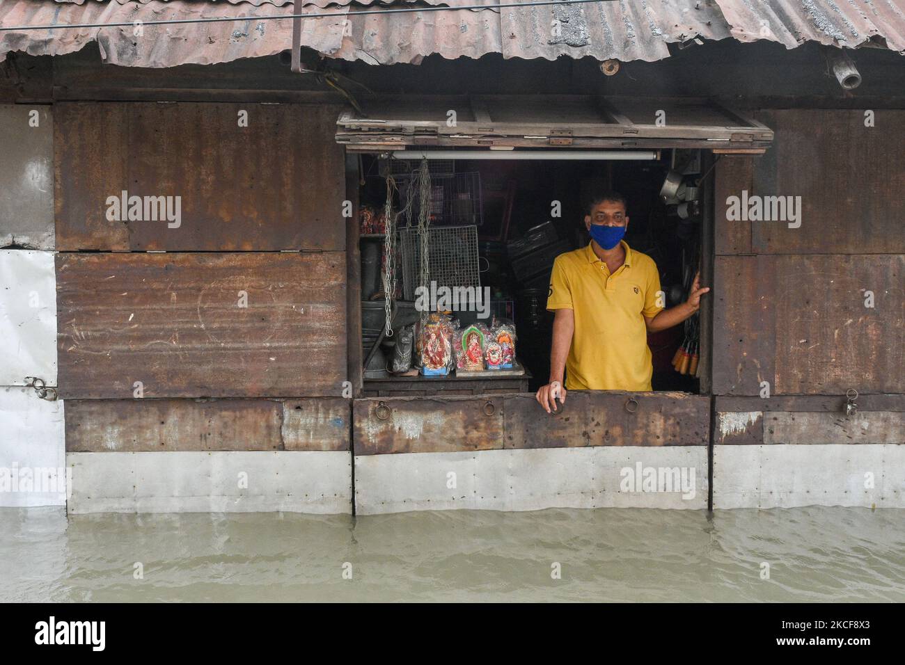 Un proprietario di negozio guarda fuori dal suo negozio in mezzo a profonde acque di alluvione a Kolkata , India , il 26 maggio 2021 . (Foto di Debarchan Chatterjee/NurPhoto) Foto Stock