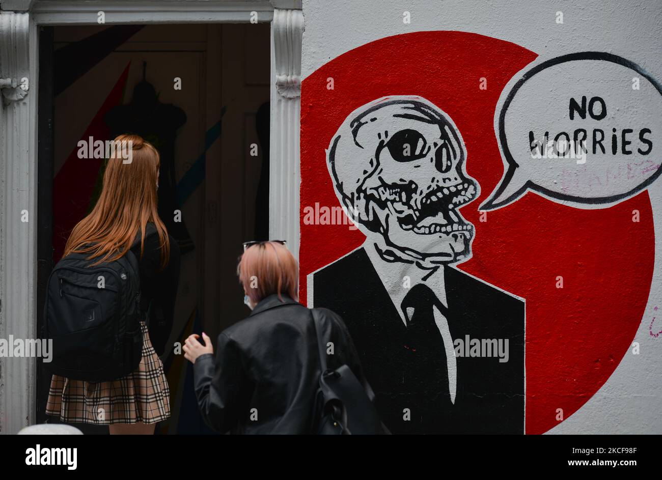 Due donne camminano davanti a un murale con le parole "NIENTE PREOCCUPAZIONI" nel centro di Dublino. Mercoledì 26 maggio 2021, a Dublino, Irlanda. (Foto di Artur Widak/NurPhoto) Foto Stock
