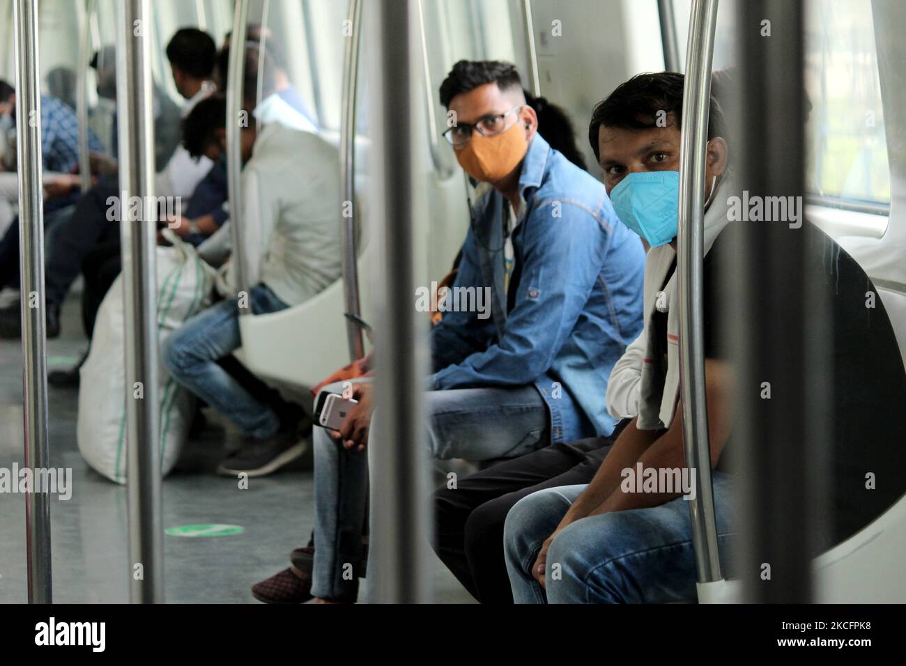 I pendolari che indossano le maschere viaggiano all'interno di un treno della metropolitana di Delhi dopo la ripresa dei servizi in modo graduale al 50% della capacità, a Nuova Delhi, India il 7 giugno 2021. Nell'ambito dello sblocco della capitale nazionale, le autorità avevano annunciato varie rilassazioni, tra cui l'apertura di negozi di liquori, mercati e centri commerciali chiusi per rallentare la diffusione della malattia del coronavirus (COVID-19). (Foto di Mayank Makhija/NurPhoto) Foto Stock