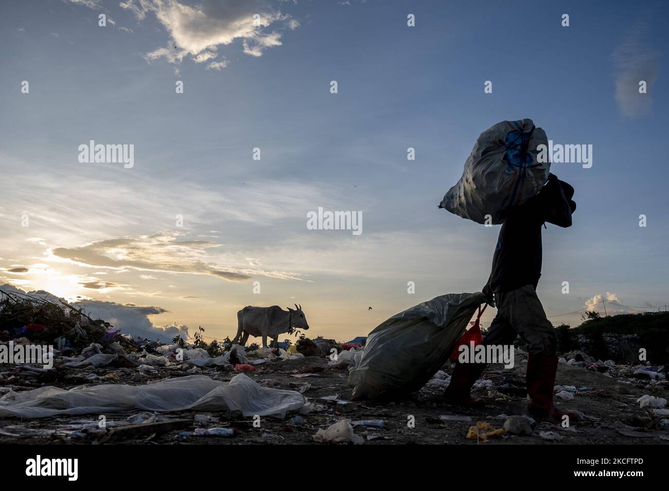 Un scavenger trasporta i beni usati dalla sua spazzatura scavenged alla discarica di Panda di poi, Kawatuna, città di Palu, provincia centrale di Sulawesi, Indonesia il 8 giugno 2021. Il Ministero indonesiano dell'ambiente ha detto che nel 2020 e nel 52 ci sono state circa 36,94 milioni di tonnellate di discariche, il 95 per cento o 19,56 milioni di tonnellate sono state gestite con il concetto del 3R (ridurre, riutilizzare e riciclare), mentre il resto non è stato gestito. Nel frattempo, il National Plastic Action Partnership (NPAP) Indonesia ha dichiarato che l'Indonesia produce circa 6,8 milioni di tonnellate di rifiuti di plastica all'anno, e il 61 per cento non viene gestito. NPAP Indonesia Foto Stock