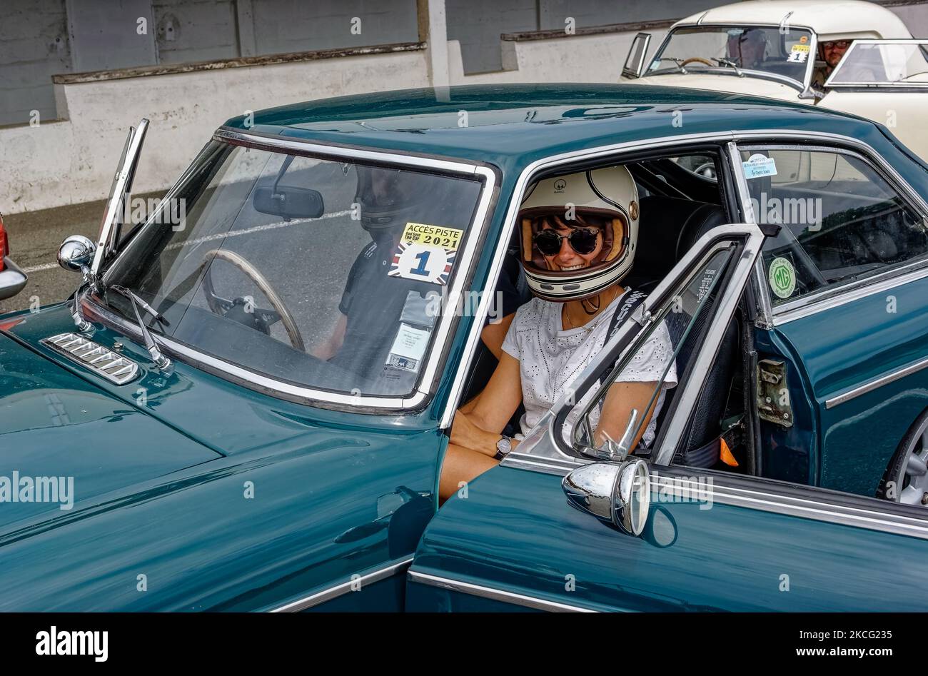 Una donna Co-pilota in un MG B nella griglia di partenza prima della Car Racing del ‘God Save the Car Festival’ con vecchie vetture inglesi al circuito automobilistico di Montlhery-Linas. Il 12 giugno 2021, a Linas, Francia. (Foto di Daniel Pier/NurPhoto) Foto Stock