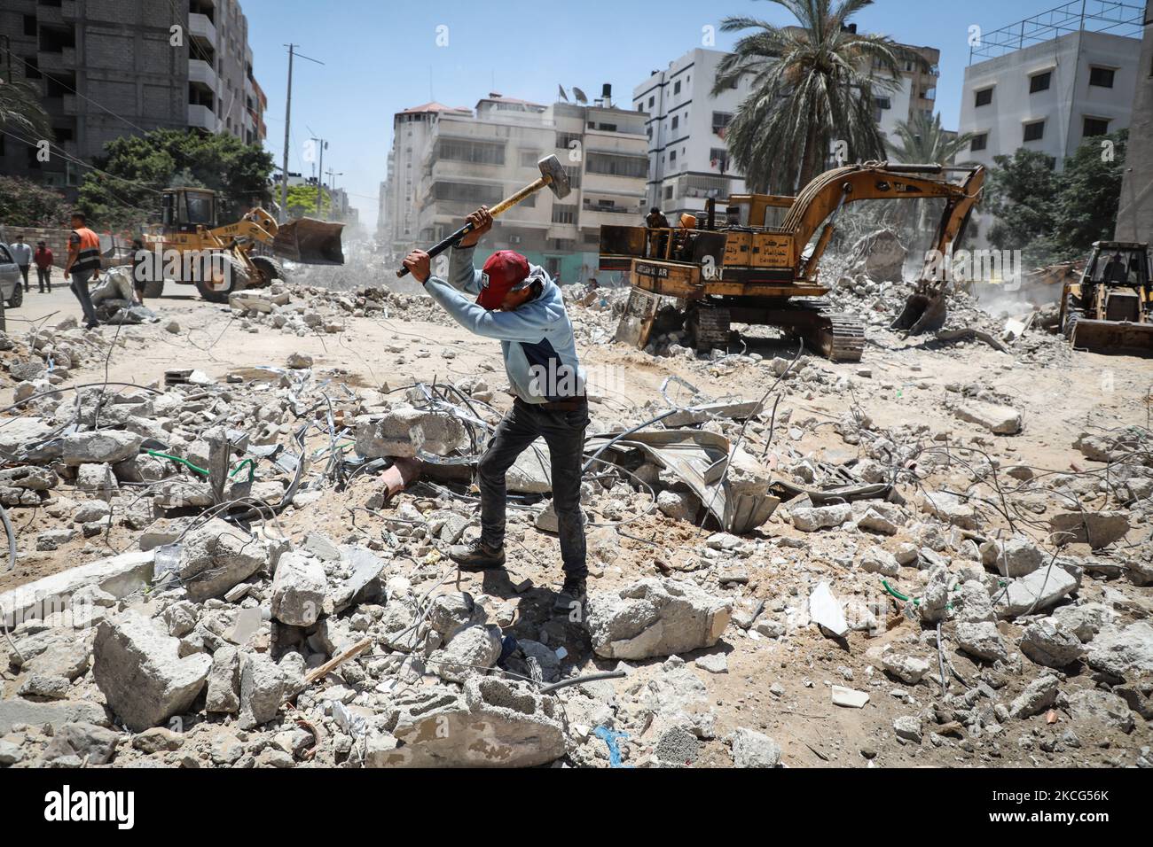 I lavoratori palestinesi e i bulldozer egiziani aiutano il 16 giugno 2021 a rimuovere le macerie delle uildings distrutte dagli attacchi aerei israeliani il mese scorso. - Dopo aver mediato un cessate il fuoco tra israeliani e governanti di Gaza del movimento di Hamas che ha raccolto il peso diplomatico internazionale dell'Egitto, il Cairo sta ora puntando su un progetto di ricostruzione di $500 milioni di dollari per rafforzare la sua influenza politica regionale. Il mese scorso, l'Egitto ha promesso mezzo miliardo di dollari per ricostruire l'enclave palestinese bloccata, che è stata bombardata da Israele per 11 giorni durante pesanti combattimenti con Hamas che si sono conclusi con un intermediario egiziano Foto Stock