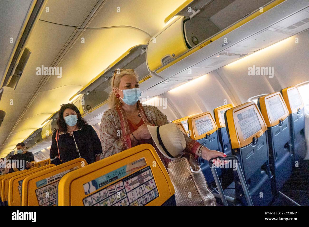 I passeggeri durante il volo indossano un facemask in cabina. Volare durante la pandemia di Coronavirus Covid-19 all'interno di un aeromobile Boeing 737-800 di Ryanair low cost con destinazione la Canea nell'isola di Creta, una popolare destinazione di vacanza. All'interno dell'aereo è obbligatorio indossare maschere facciali per i passeggeri e l'equipaggio di volo, la guardia aerea, ecc. mentre le persone hanno bisogno di un test COVID negativo per salire a bordo dell'aereo come misura di sicurezza, mentre l'industria aeronautica e turistica sta lottando per tornare alla normalità. La Grecia sta cercando di incentivare il proprio turismo e concedere privilegi per vaccinare contro la Cov Foto Stock