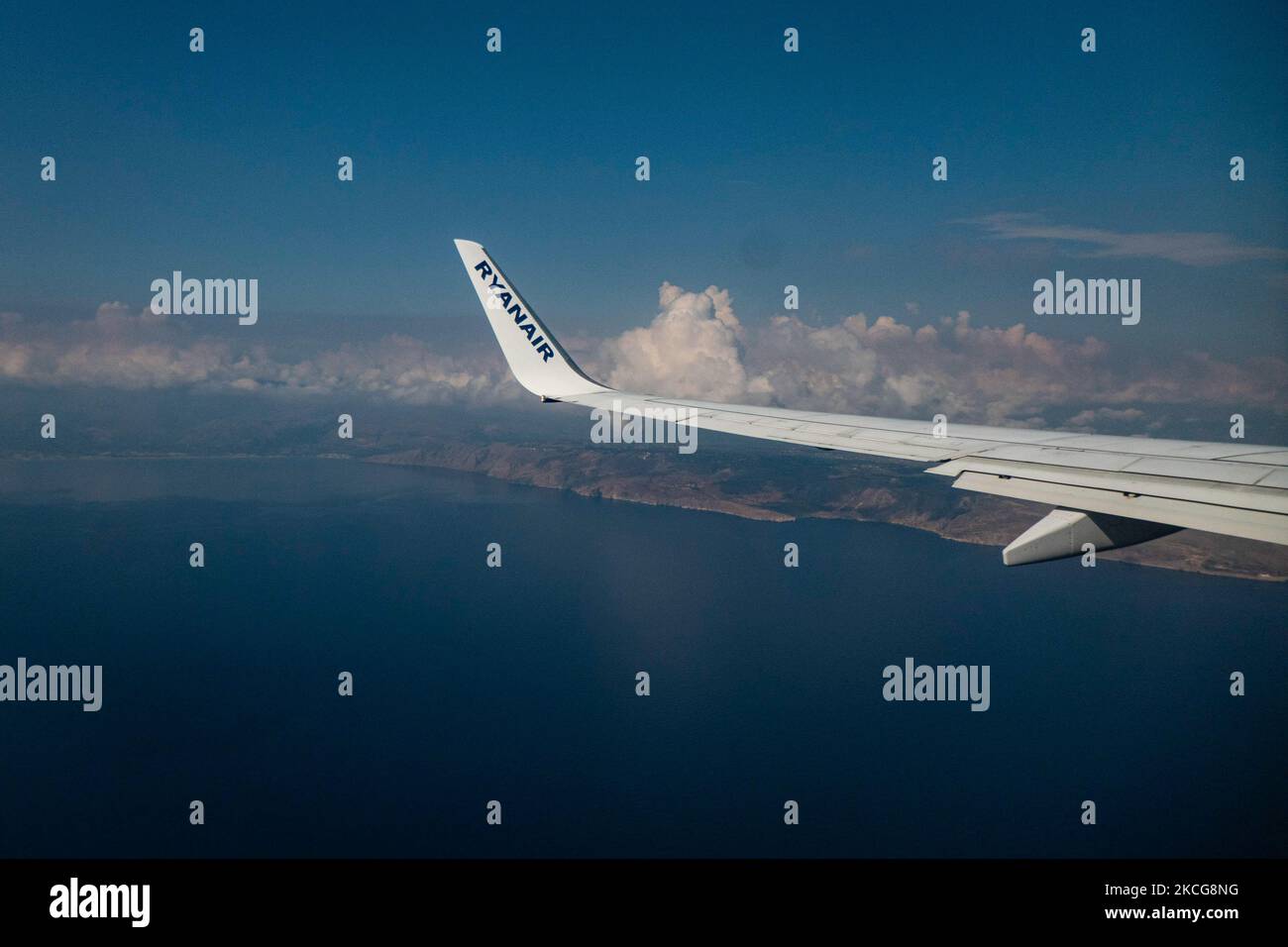 Vista sull'ala con logo RYANAIR mentre atterra sull'isola mediterranea di Creta. Volare durante la pandemia di Coronavirus Covid-19 all'interno di un aeromobile Boeing 737-800 di Ryanair low cost con destinazione la Canea nell'isola di Creta, una popolare destinazione di vacanza. All'interno dell'aereo è obbligatorio indossare maschere facciali per i passeggeri e l'equipaggio di volo, la guardia aerea, ecc. mentre le persone hanno bisogno di un test COVID negativo per salire a bordo dell'aereo come misura di sicurezza, mentre l'industria aeronautica e turistica sta lottando per tornare alla normalità. La Grecia sta cercando di rilanciare il suo turismo e di dare privilegi a v Foto Stock