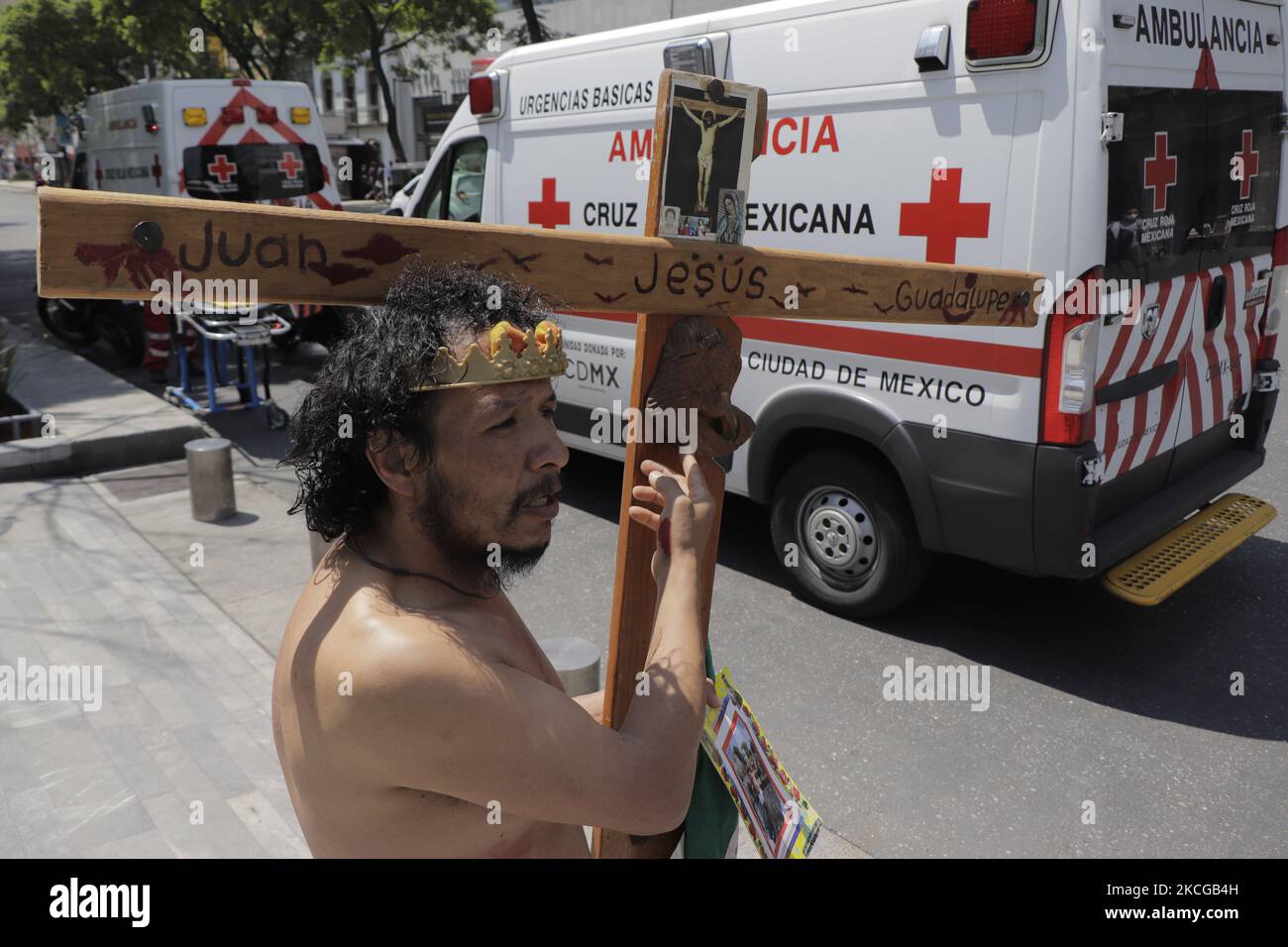 Una persona vestita come Gesù Cristo tiene una croce di fronte alle ambulanze durante il primo simulacro Nazionale 2021 su Avenida Juárez, Città del Messico. Durante il simulacro, servizi di emergenza come vigili del fuoco, polizia, Croce Rossa e personale del Segretariato di Gestione integrale del rischio e protezione civile del capitale sono stati dispiegati in caso di terremoto di 8,1 Richter con un epicentro a Guerrero, con una percezione molto forte. (Foto di Gerardo Vieyra/NurPhoto) Foto Stock