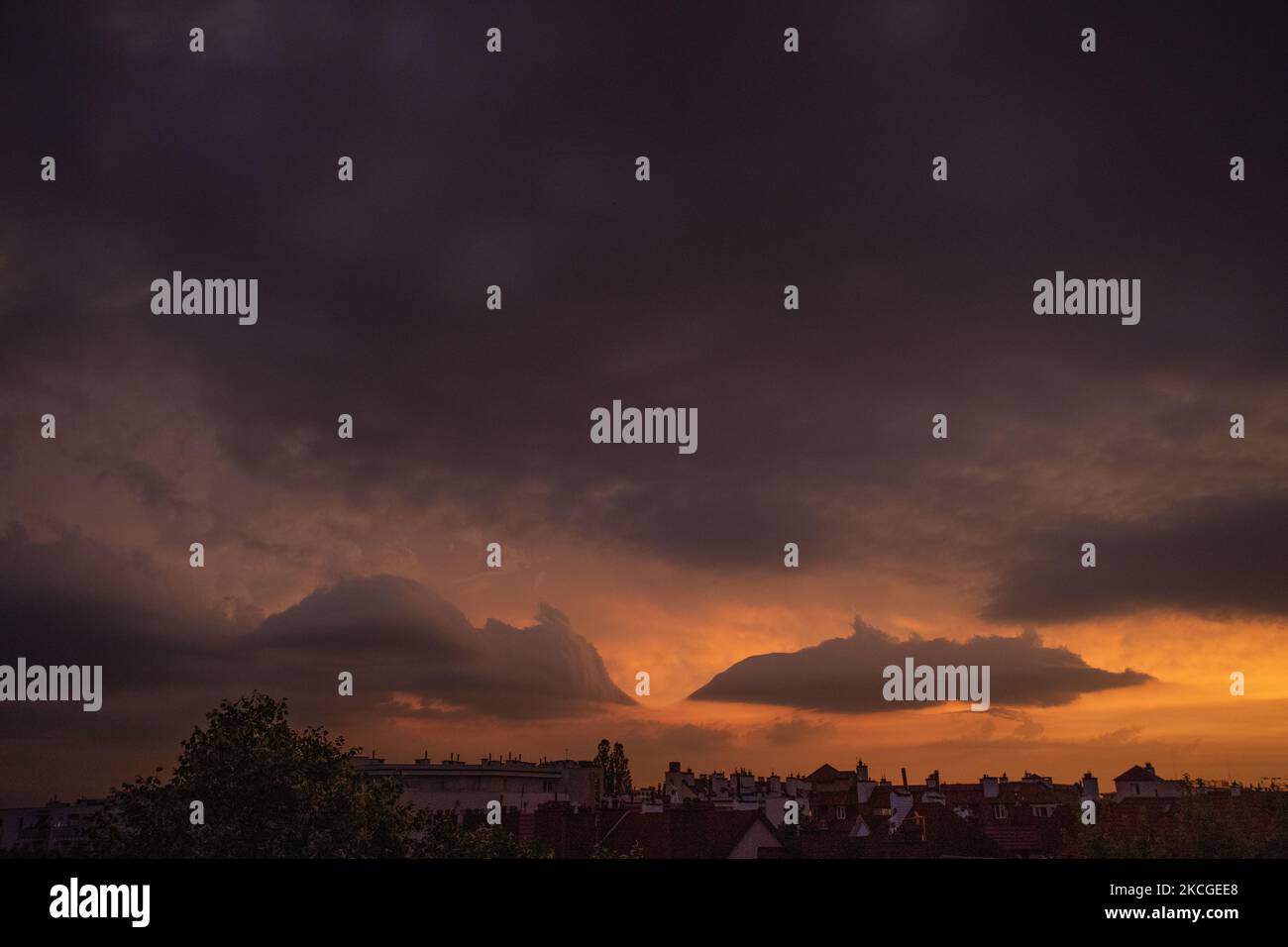 Le nuvole si vedono raccolte sopra la città mentre il sole tramonta dando i colori del cielo a Varsavia, Polonia, il 24 giugno 2021. La Polonia è stata sweltering da un'onda di calore con termperature ben al di sopra di 30 gradi centigradi. Le piogge hanno dato un breve sollievo alle aree sevaerali del paese abbassando la temperatura di alcuni gradi. (Foto di Str/NurPhoto) Foto Stock