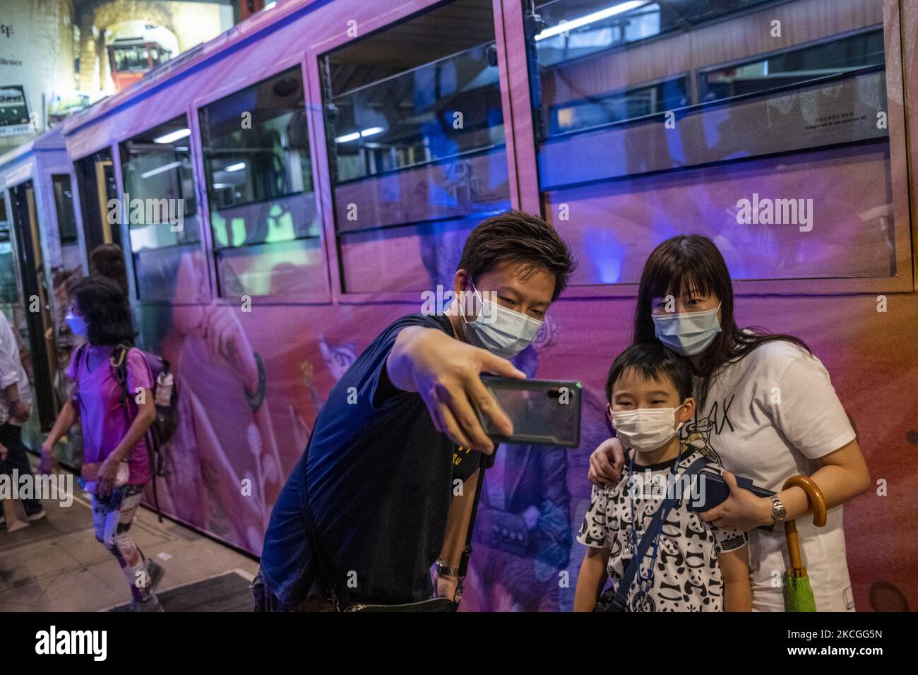 La gente posa per una foto con il tram di picco a Hong Kong, Cina, il 26 giugno 2021. Il Peak tram fermerà a partire da giugno 28 per lavori di ristrutturazione. (Foto di Vernon Yuen/NurPhoto) Foto Stock