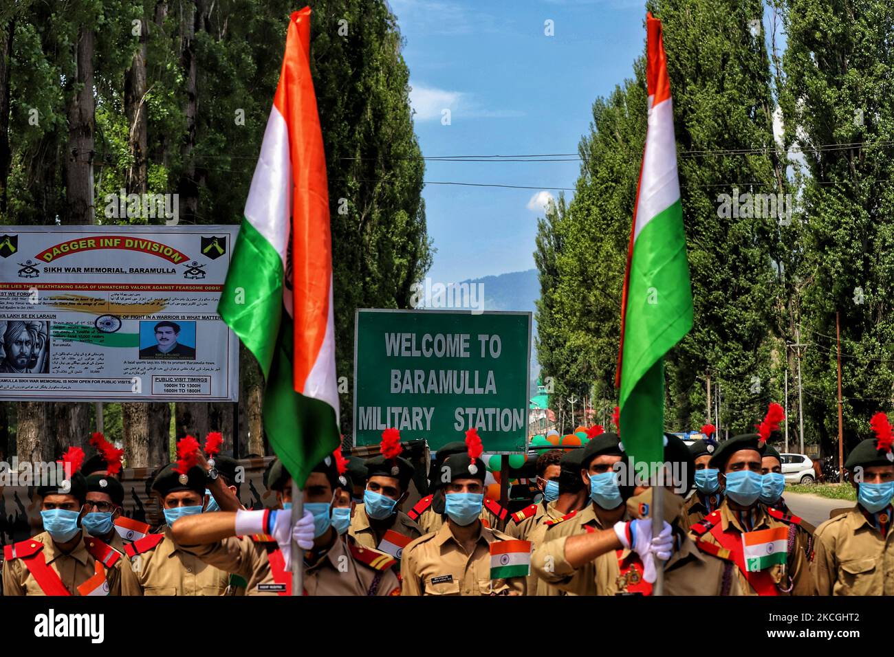 Benvenuti alla Stazione militare di Baramulla scritta su un bordo come Cadetti NCC che detengono bandiere nazionali indiane prepararsi a partecipare a un evento a Baramulla, Jammu e Kashmir, India il 27 giugno 2021. (Foto di Nasir Kachroo/NurPhoto) Foto Stock