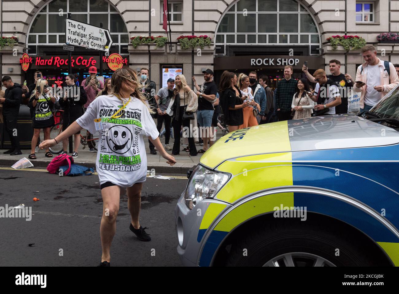 LONDRA, REGNO UNITO - 27 GIUGNO 2021: Una donna balla davanti a un'auto della polizia mentre migliaia di persone prendono parte a una marcia di protesta "Freedom to Dance" attraverso il centro di Londra organizzata da Save Our Scene chiedendo che il governo britannico sollevi senza ulteriori ritardi le restrizioni del coronavirus imposte al settore della musica e dell'ospitalità il prossimo giugno 27, 2021 a Londra, Inghilterra. L'economia notturna del Regno Unito è stata pesantamente influenzata dalle restrizioni del Covid-19, con la maggior parte dei locali chiusi dall'inizio della pandemia. (Foto di Wiktor Szymanowicz/NurPhoto) Foto Stock LONDRA, REGNO UNITO - 27 GIUGNO 2021: Una donna balla davanti a un'auto della polizia mentre migliaia di persone prendono parte a una marcia di protesta "Freedom to Dance" attraverso il centro di Londra organizzata da Save Our Scene chiedendo che il governo britannico sollevi senza ulteriori ritardi le restrizioni del coronavirus imposte al settore della musica e dell'ospitalità il prossimo giugno 27, 2021 a Londra, Inghilterra. L'economia notturna del Regno Unito è stata pesantamente influenzata dalle restrizioni del Covid-19, con la maggior parte dei locali chiusi dall'inizio della pandemia. (Foto di Wiktor Szymanowicz/NurPhoto) Foto Stock