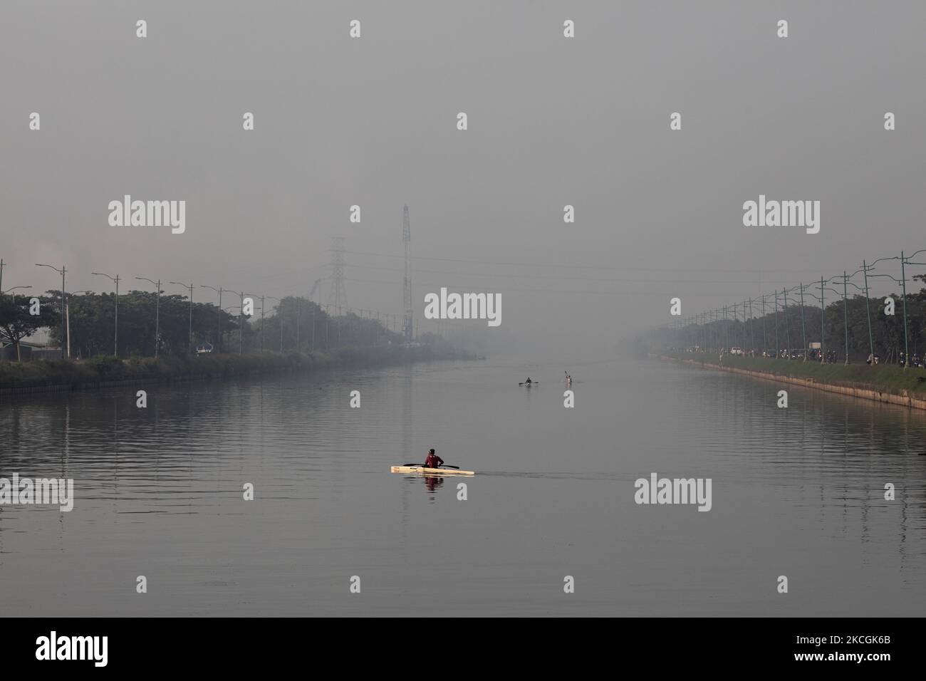 Gli atleti di canottaggio stanno esercitandosi sul fiume altamente inquinato dal canale di inondazione orientale a Jakarta, Indonesia, il 28 giugno 2021. (Foto di Donal Husni/NurPhoto) Foto Stock