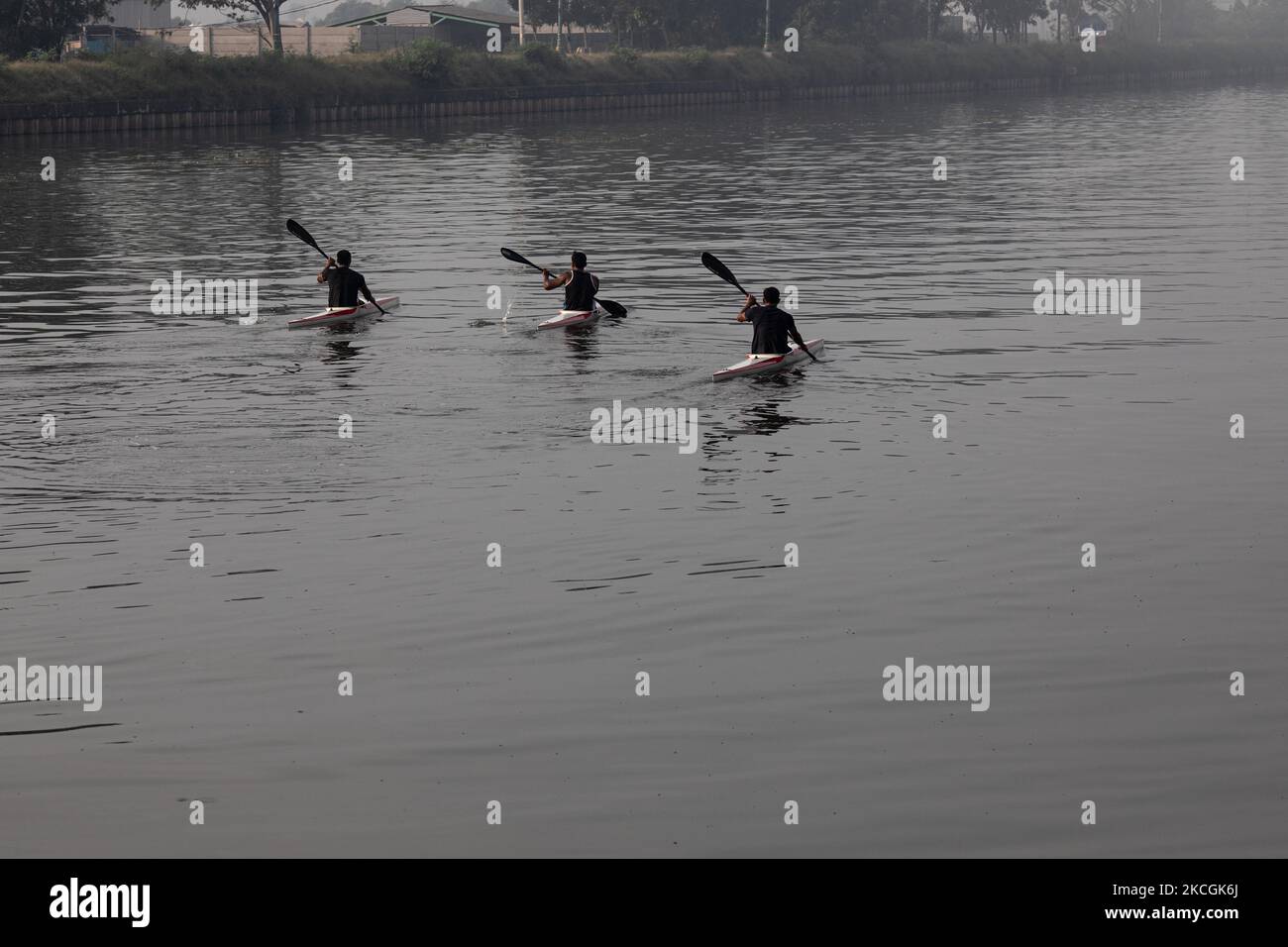 Gli atleti di canottaggio stanno esercitandosi sul fiume altamente inquinato dal canale di inondazione orientale a Jakarta, Indonesia, il 28 giugno 2021. (Foto di Donal Husni/NurPhoto) Foto Stock
