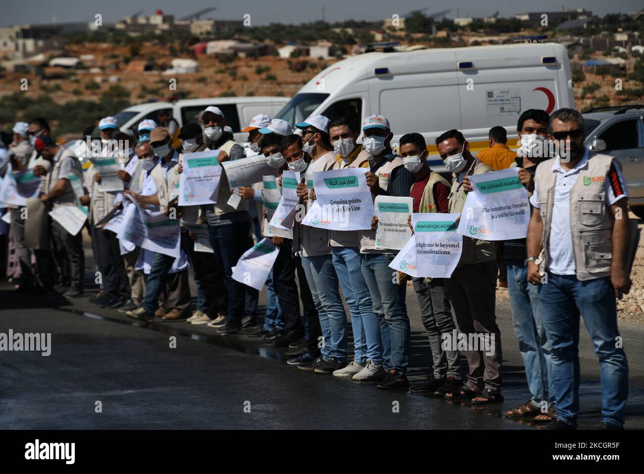 Proteste per consentire l'ingresso degli aiuti umanitari in Siria il 2 luglio 2021 ad Idlib, Siria. Una catena umana è formata da lavoratori della società civile, aiuti umanitari, E i servizi medici e di soccorso in una veglia che chiede di mantenere una risoluzione delle Nazioni Unite che autorizzi il passaggio di aiuti umanitari nella regione nordoccidentale dell'Idlib in Siria, il valico di frontiera di Bab al-Hawa, vicino a Bab al-Hawa, lungo l'autostrada che lo collega alla città di Idlib. Il Consiglio di sicurezza delle Nazioni Unite è in fase di votazione su un progetto di estensione del meccanismo di aiuti transfrontalieri, in mezzo ai timori di un veto russo, la Russia mi ha detto Foto Stock