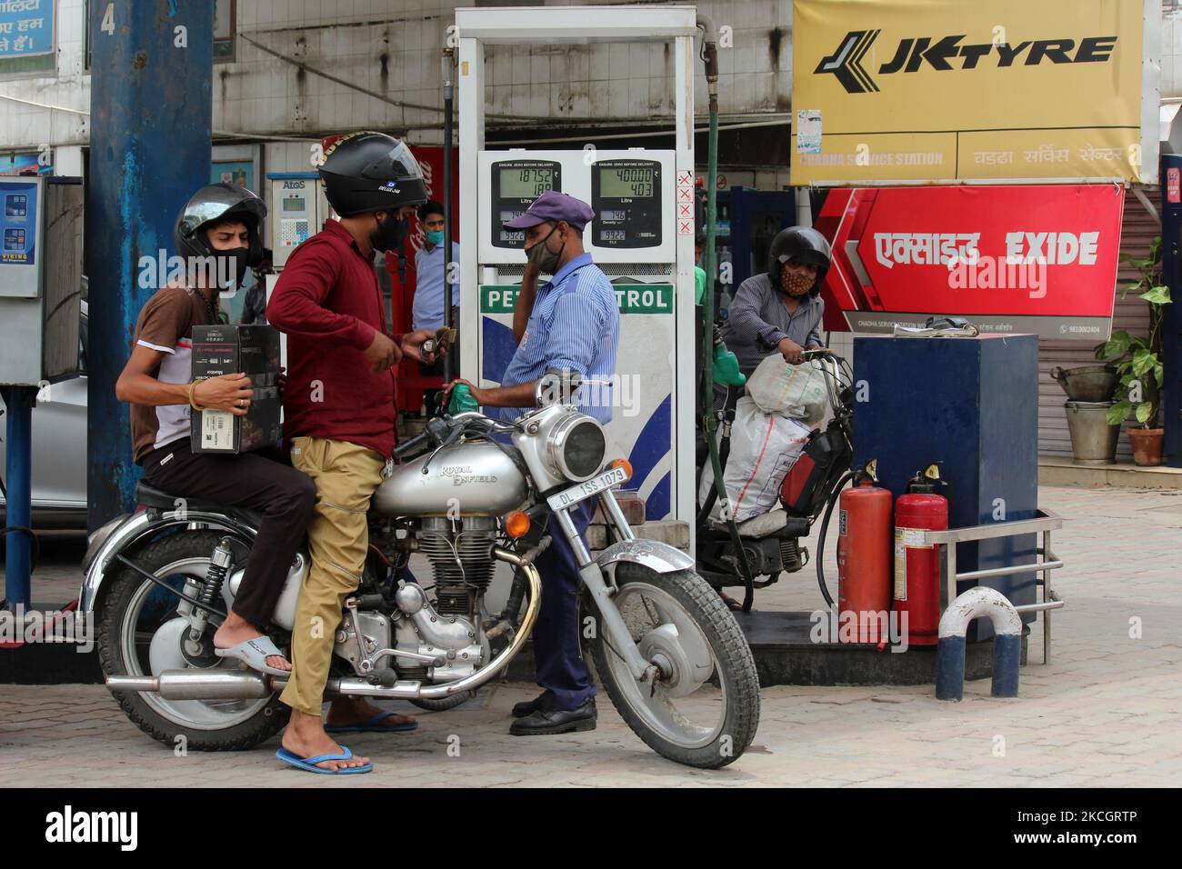 Un addetto alla stazione di rifornimento pompa benzina in un veicolo a due ruote in una stazione di rifornimento a Nuova Delhi, India il 3 luglio 2021. Il prezzo della benzina a Delhi ha violato?99 per il contrassegno del litro ed attualmente si leva in piedi a?99,16 mentre il diesel continua a vendere a?89,18. I prezzi del carburante e del gas stanno toccando un picco record in tutto il paese. (Foto di Mayank Makhija/NurPhoto) Foto Stock