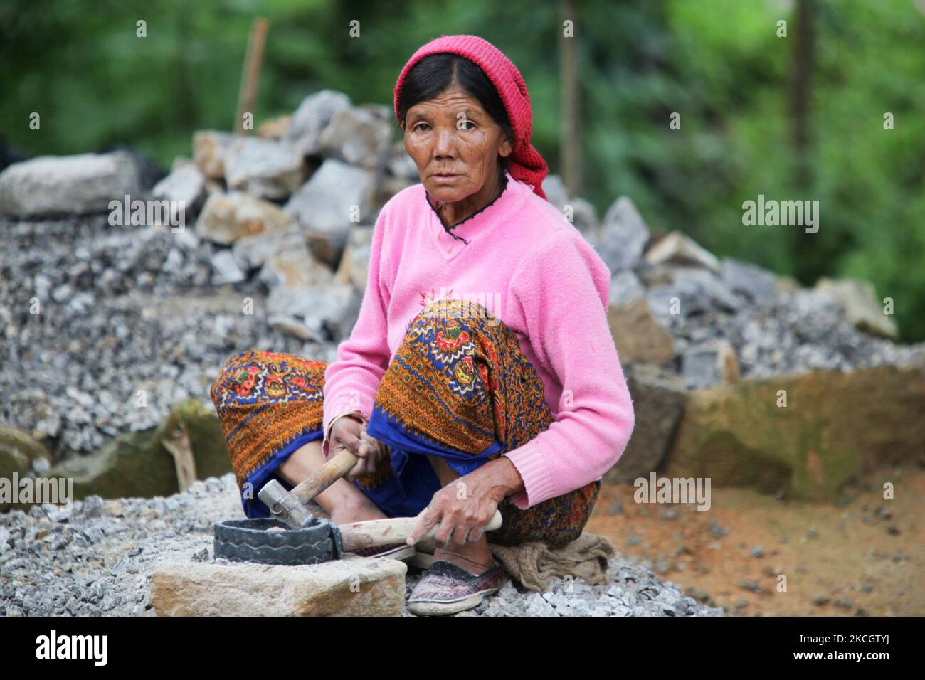 La donna nepalese lavora sassi in ghiaia con un attrezzo di gomma con un manico di legno ed un piccolo martello in Khechuperi, Sikkim, India. La ghiaia sarà usata per fare cemento per costruzione. (Foto di Creative Touch Imaging Ltd./NurPhoto) Foto Stock