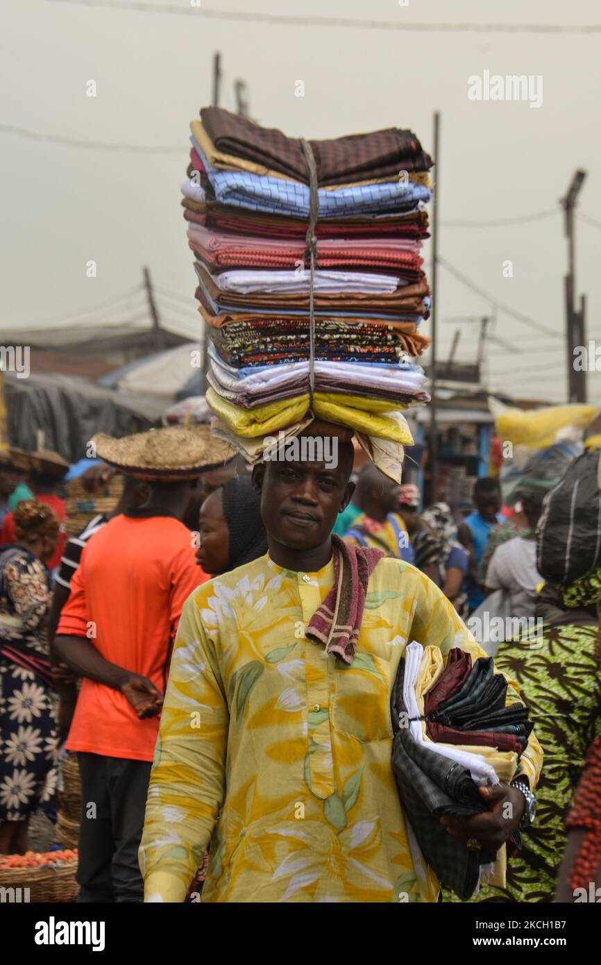 Un venditore di stoffe che trasporta i panni sulla sua testa al mercato di miglio 12 a Lagos, i prezzi del cibo rimangono elevati nonostante il calo del tasso di inflazione al 17,93% nel maggio 2021, il 7 luglio 2021. La Banca Mondiale ha affermato che l’aumento dell’inflazione e dei prezzi del paese hanno spinto circa sette milioni di nigeriani al di sotto della soglia di povertà nel 2020. L'aumento dell'indice alimentare è stato causato dall'aumento dei prezzi del pane, dei cereali, del latte, del formaggio, delle uova, Pesce, bevande analcoliche, caffè, tè e cacao, frutta, Carne, oli e grassi, e vegetali. (Foto di Olukayode Jaiyeola/NurPhoto) Foto Stock