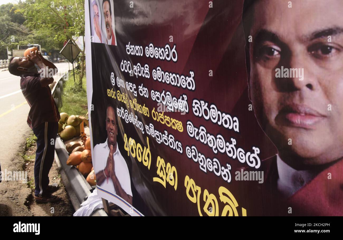 Un uomo beve una noce di cocco vicino a una piccola stalla stradale a Colombo, Sri Lanka 9 luglio 2021 (Foto di Achila Jayawardana/NurPhoto) Foto Stock