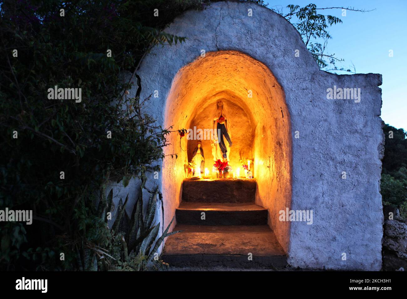 Le candele bruciano in serata in un santuario illuminato della Vergine Maria nella città di Hanga Roa sull'isola di Pasqua, Cile, il 13 marzo 2010. (Foto di Creative Touch Imaging Ltd./NurPhoto) Foto Stock